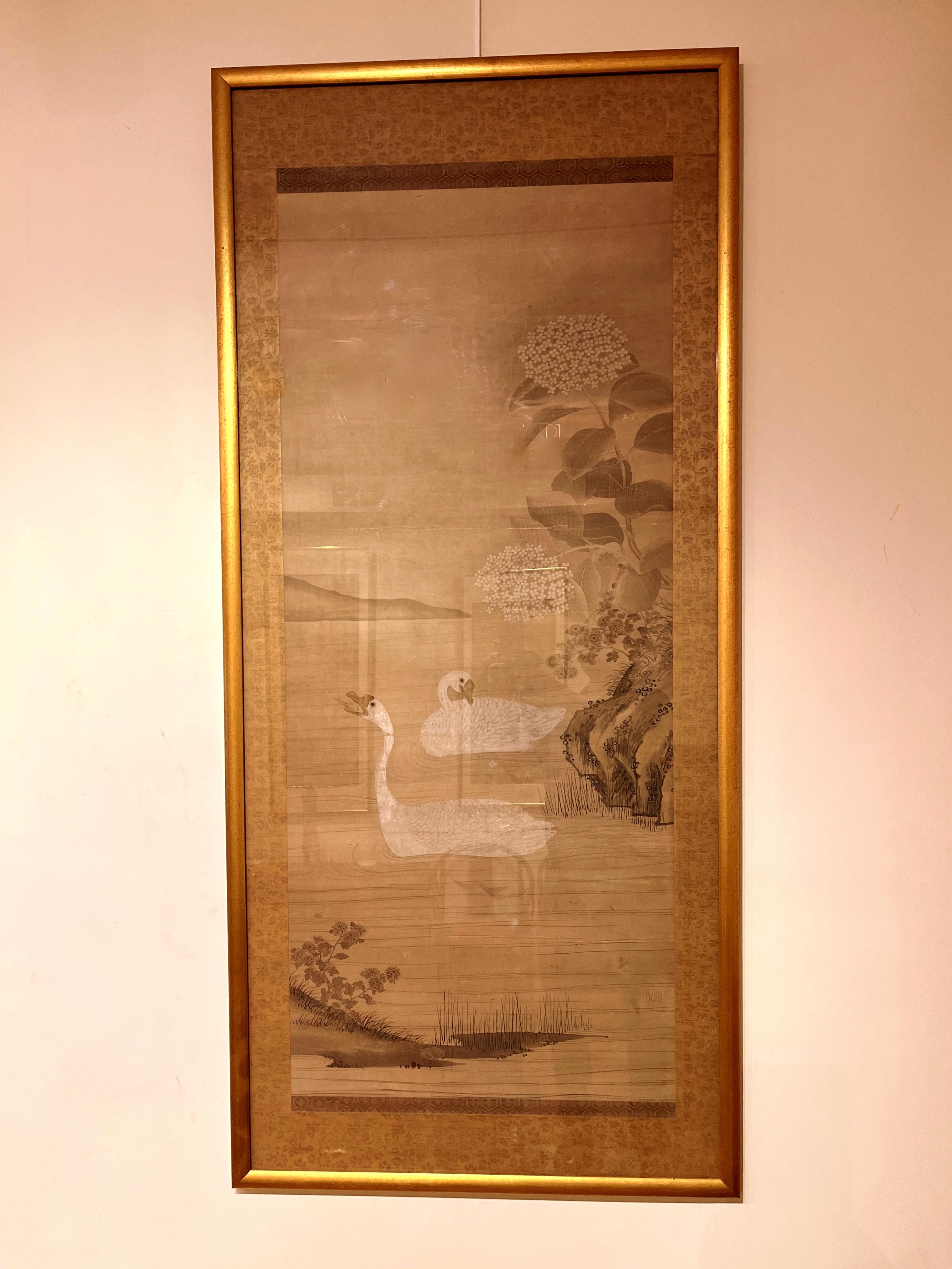 Framed Japanese brush painting of two white geese swimming in a pond, 
19th century, ink on paper, original brocade mount.
Overall size with frame:  58