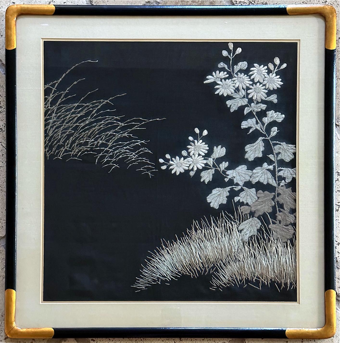 A Japanese textile panel with embroidery needlework circa late Meiji period (1900s) presented in a gilt wood frame with silk mat. The work depicts a lovely arrangement of Japanese chrysanthemum flowers with autumn grasses swaying the wind. Silk