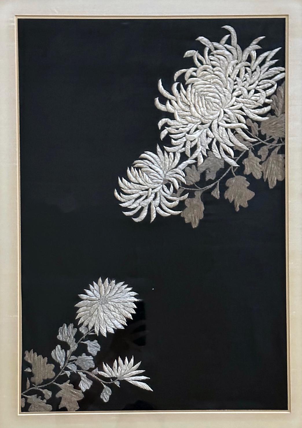 A Japanese textile panel with embroidered picture work circa late Meiji period (1900s) presented in a gilt wood frame with silk mat. The work depicts a lovely arrangement of two different varieties of Japanese chrysanthemum flowers. Silk threads of