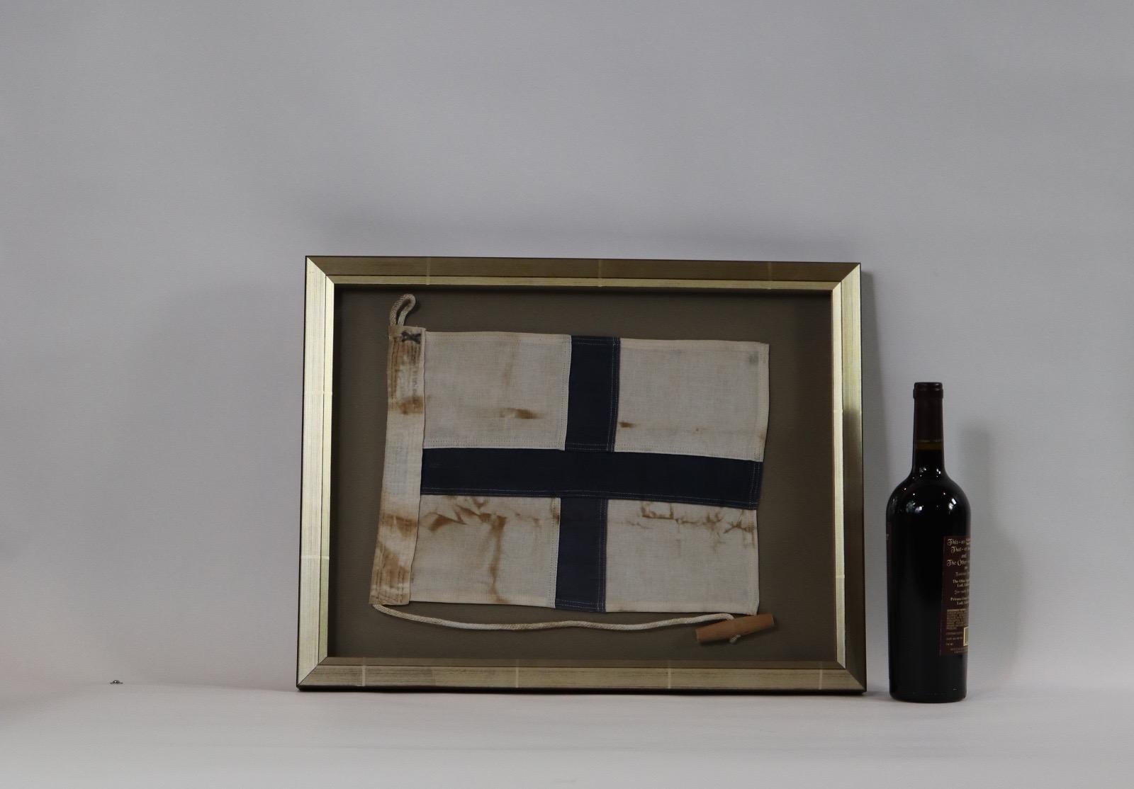Shadow box framed ships signal flag with attached rope and wood toggle. White and red field. Weight is 5 pounds.