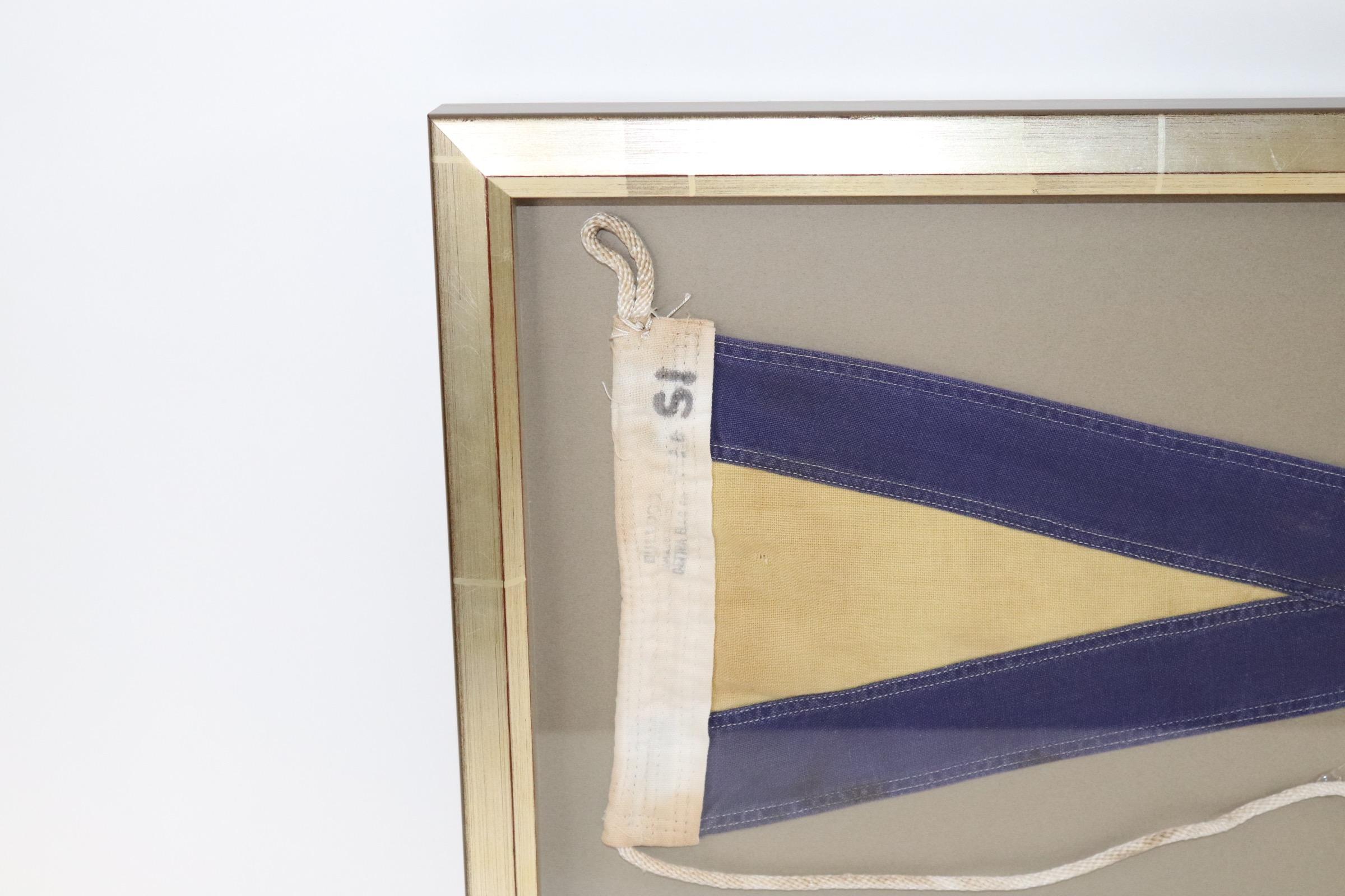 Shadow box framed ships signal flag with attached rope and wood toggle. Blue field with yellow. Weight is 5 pounds.