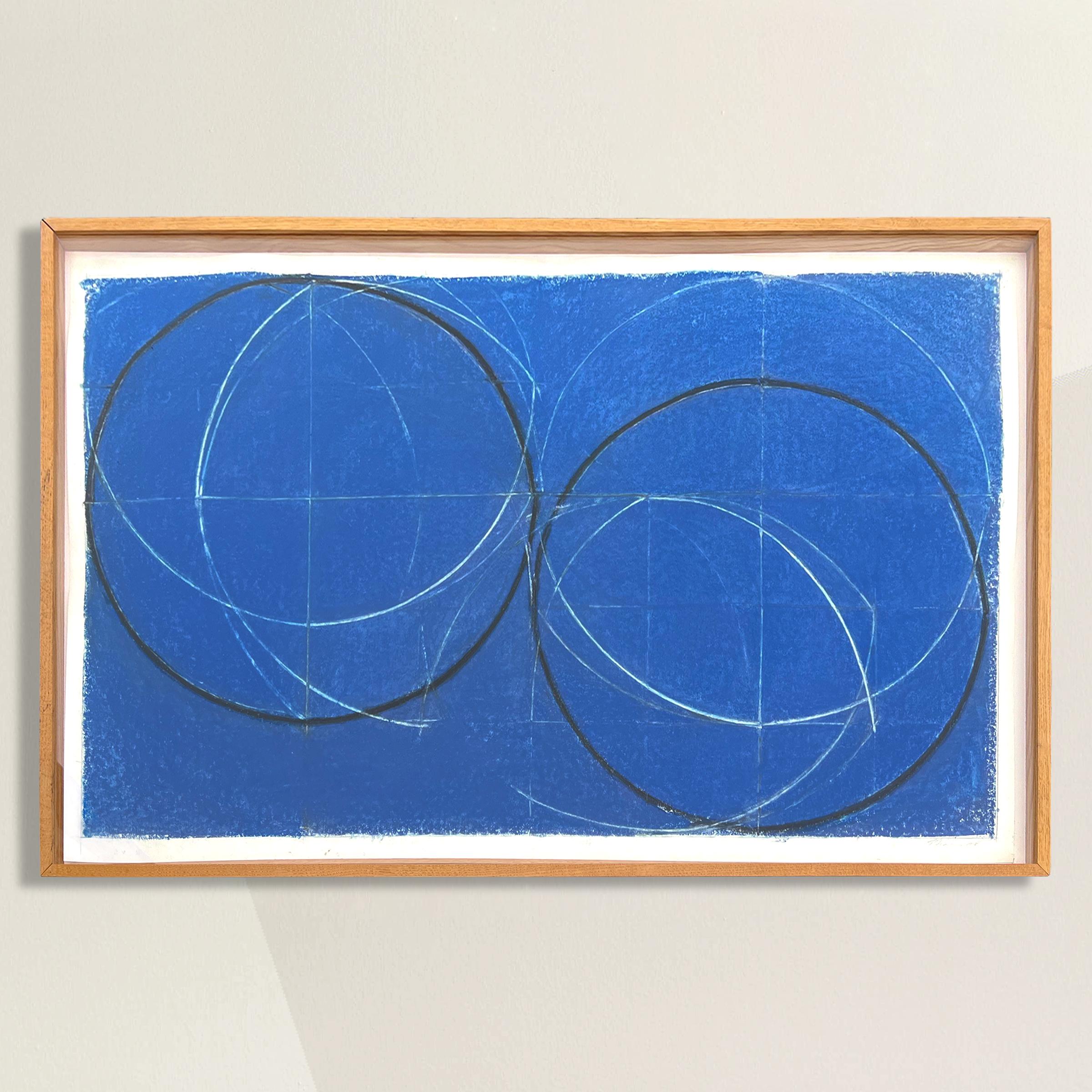 A chic and impactful American Minimalist geometric drawing with two large charcoal circles, several interlocking white circles, and set against a bold cobalt blue pastel background. Framed in a custom oak gallery frame. Signed and dated illegibly in