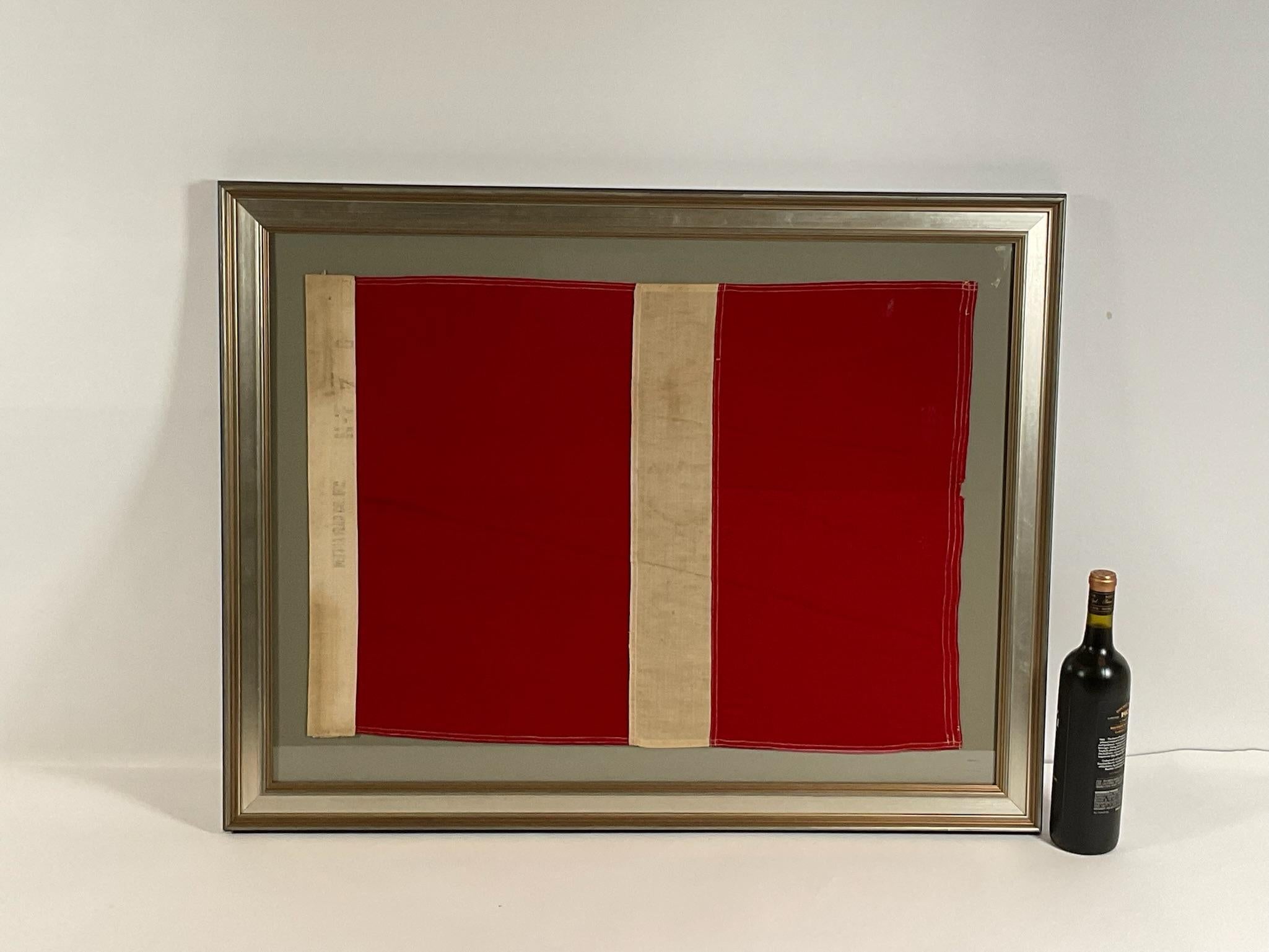 Linen maritime flag with sturdy canvas hoist and stitched panels of red and white. The hoist is stamped Dettra Flag Company Incorporated. This is a US Navy signal for number SEVEN, signal code 