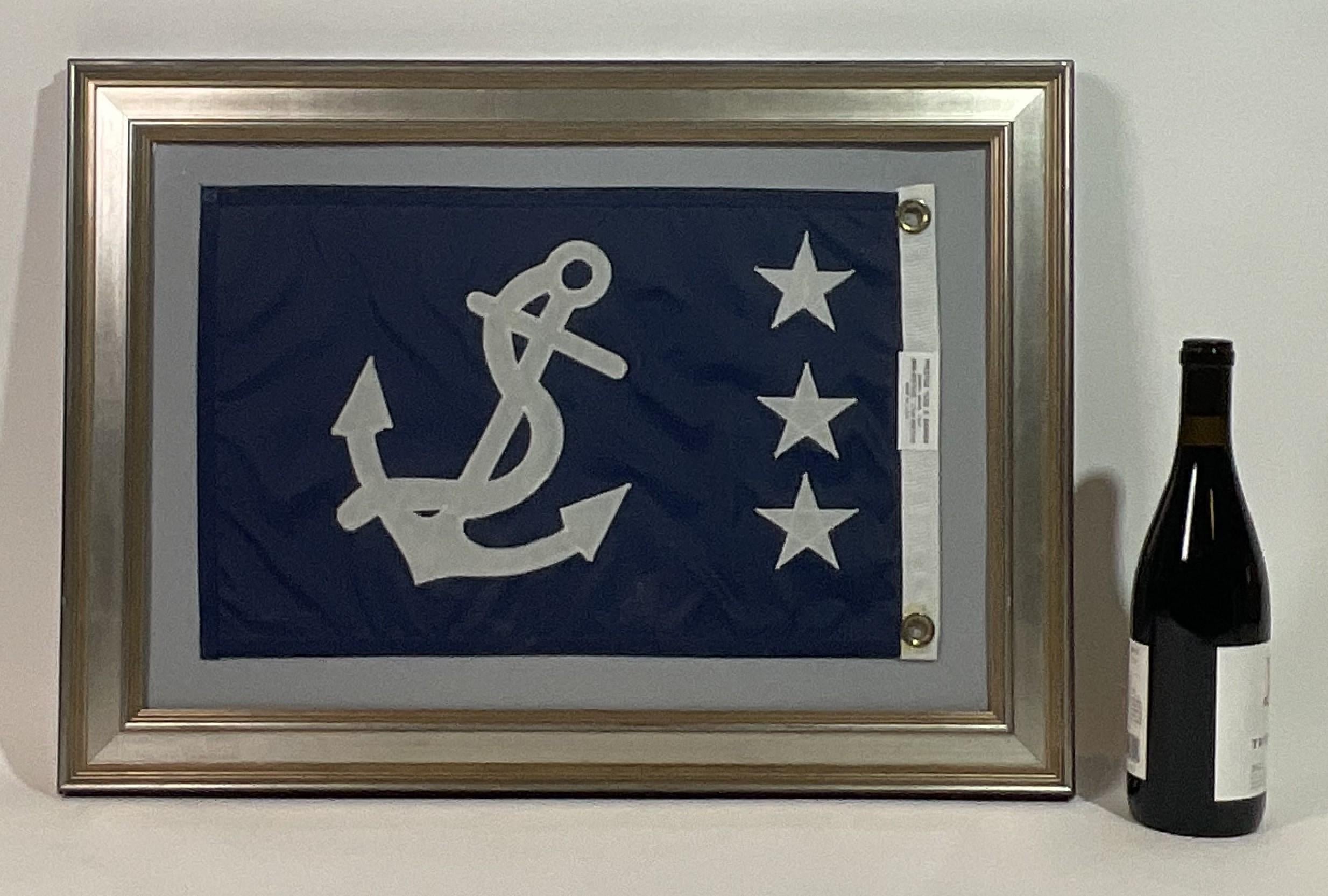 Marine flag showing a fouled anchor with three stars, which signify that a past yacht club's commodore is on board. Blue field with white anchor and stars, set on gray matting and framed.

Weight:    7 lbs.
Overall Dimensions:    19