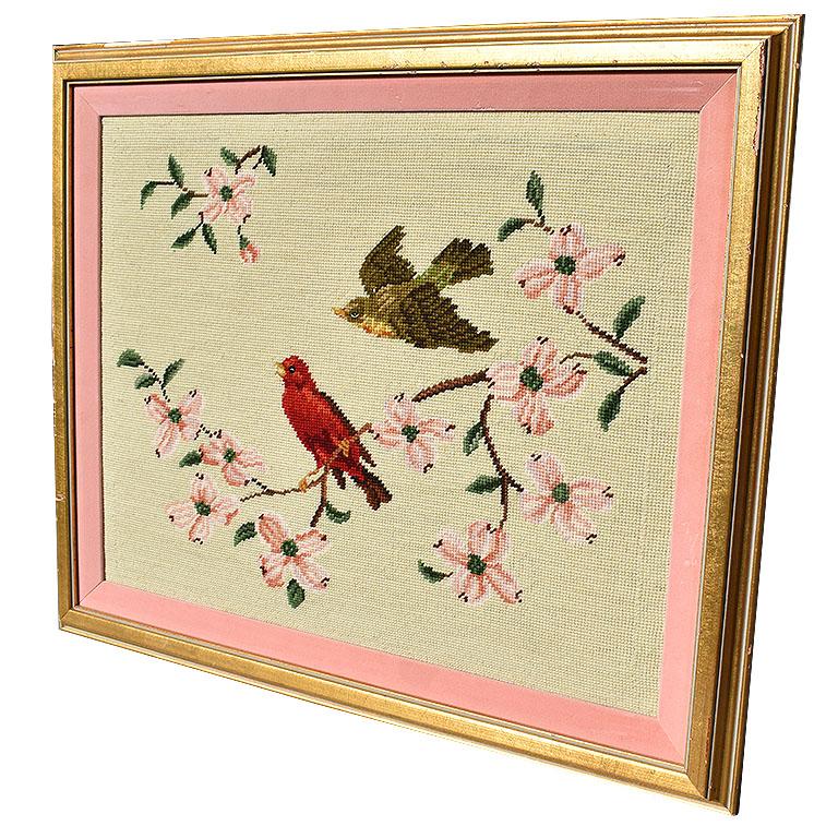 Giltwood framed needlepoint wall hanging of flora and fauna. This beauty is a lovely nod to Spring. With a giltwood frame and pink velvet mat inlay it brings a cheery vibe to every onlooker. Pink cherry blossoms play nicely off the pale pink mat.