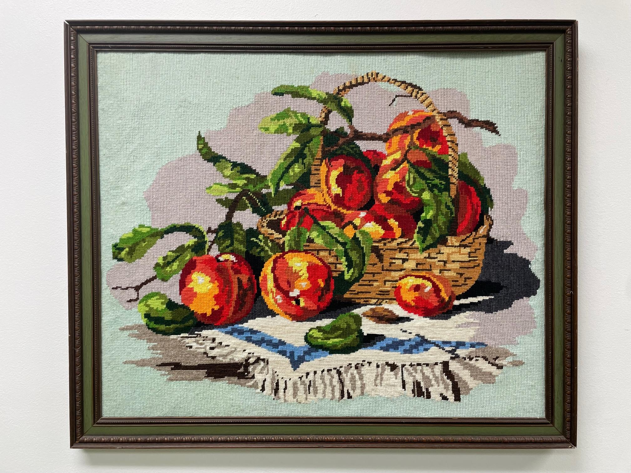 Cette tapisserie à l'aiguille vintage encadrée présente une nature morte complexe représentant une coupe de fruits et un cadre en bois massif. Bon état avec des imperfections mineures correspondant à l'âge, voir les photos pour les détails de