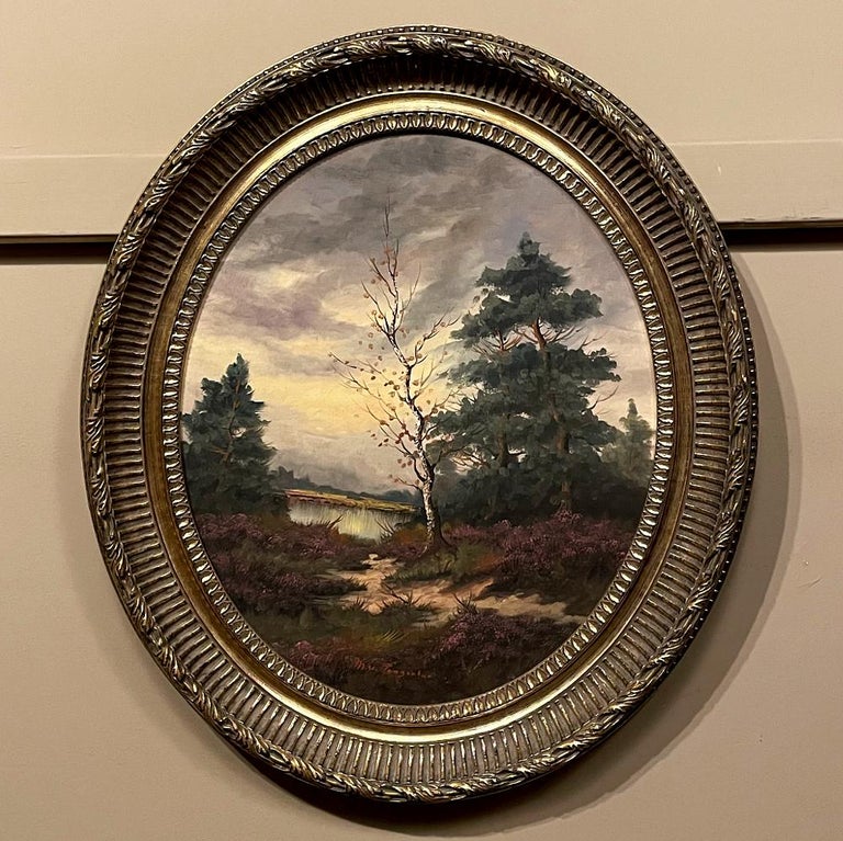 Framed Oval Oil Painting on Panel by M V Tongerloo is a delightful landscape rendered in an unusual vertical oval format. The artist has employed cool colors to create a sense that the time depicted is around dusk. The sandy, sparsely treed area
