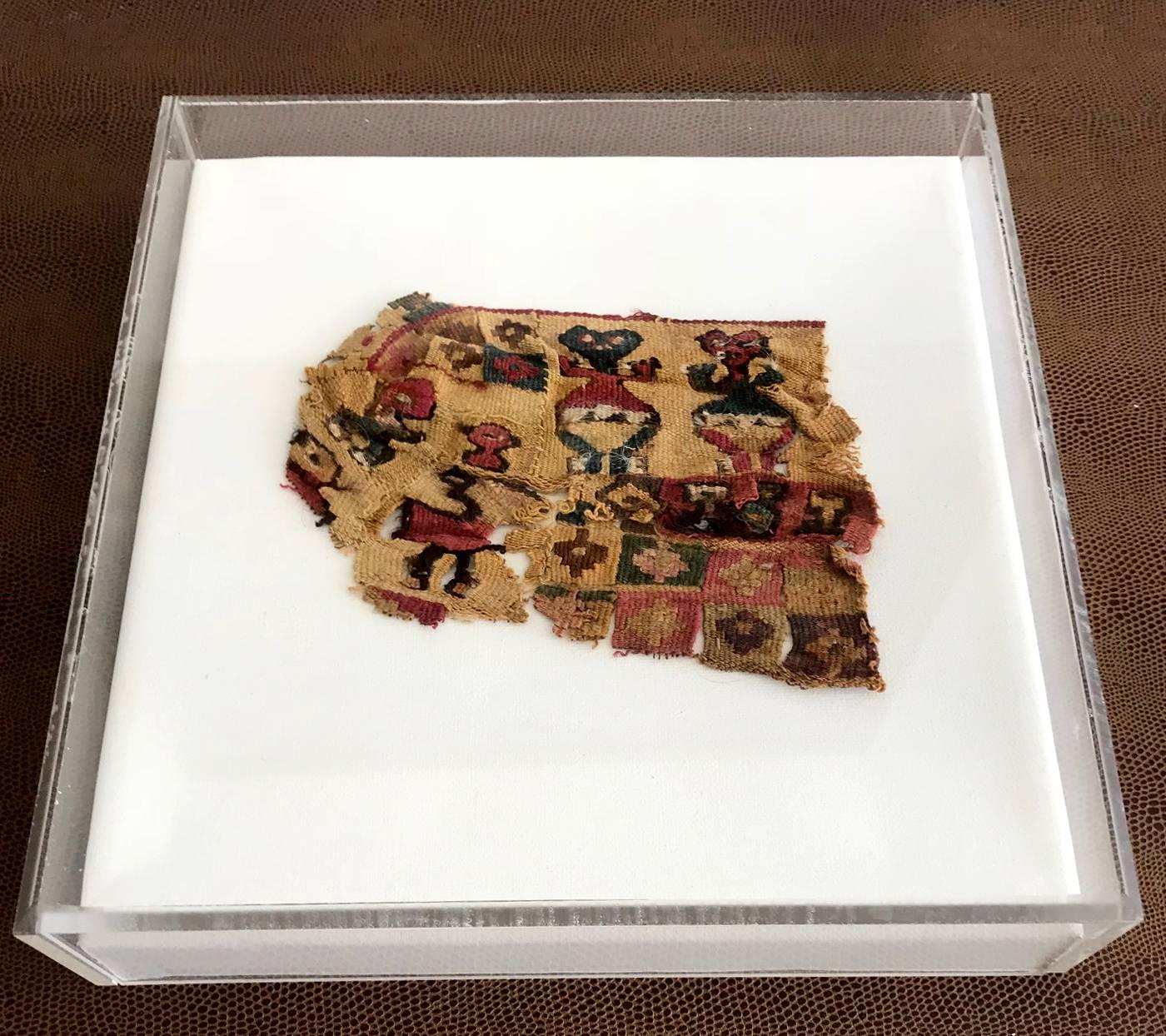 A small piece of Pre-Columbian antique textile fragment in a Lucite shadow box. Attributed to the Tiahuanaco or Tiwanaku culture, based in the city of Tiwanaku in western Bolivia that extended around Lake Titicaca and into present-day Peru and Chile