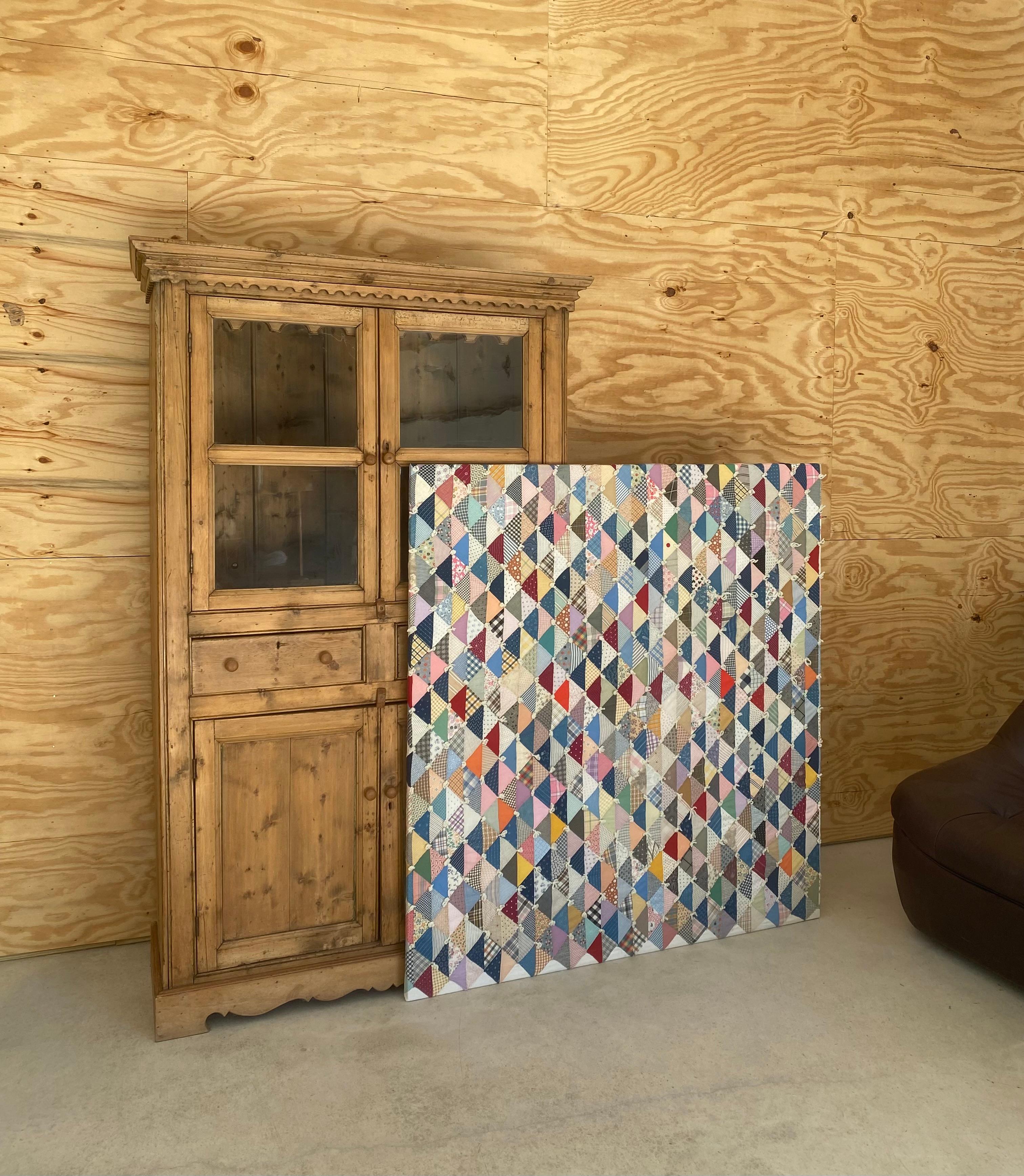 A framed quilt from the 1950s, created with textiles from the prior two decades, the 1930s-1940s. Lovely textures and colors and most importantly, a perfectly Americana Modernism piece for wall display as art. Stretched on a wood frame and strung