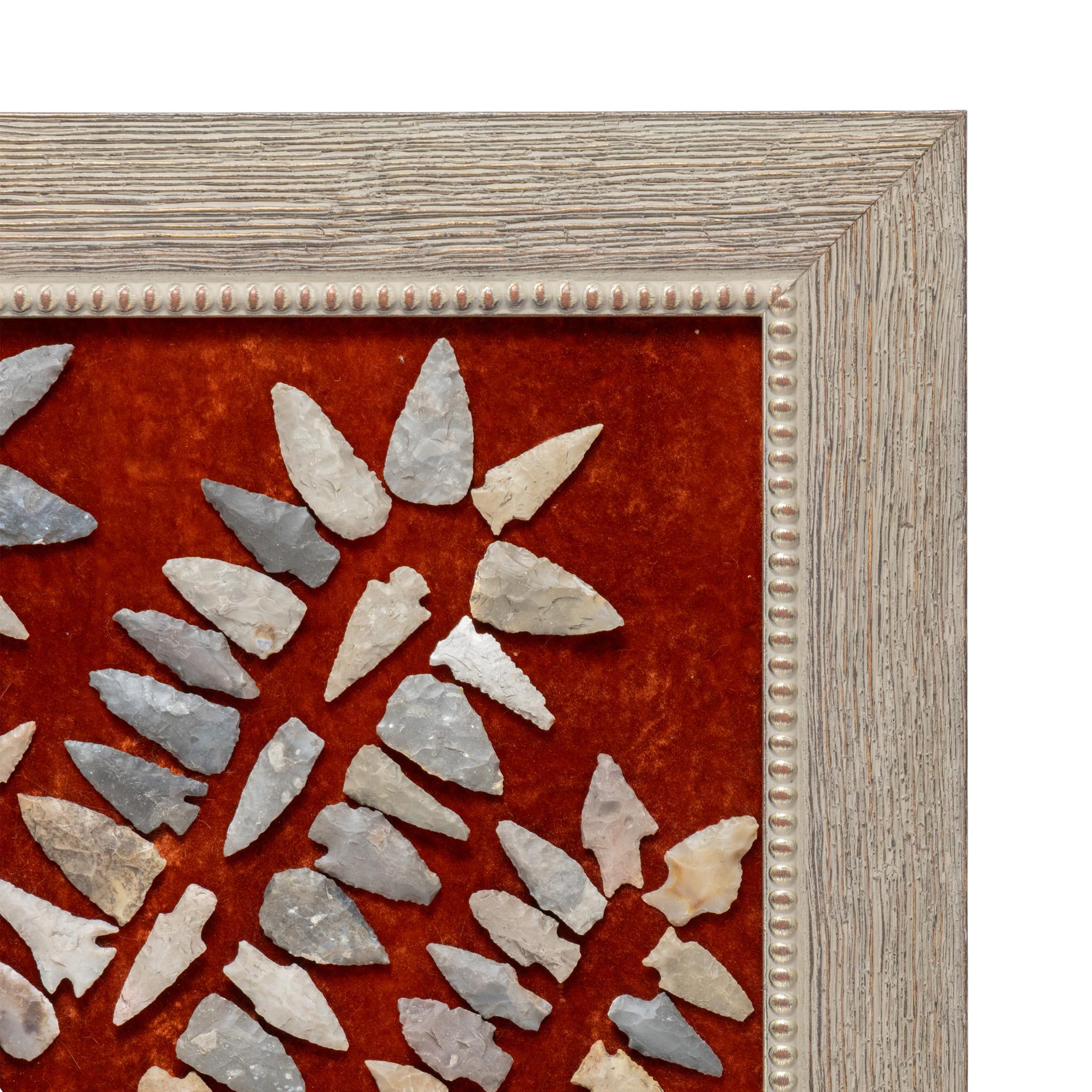Framed collection of 108 prehistoric Texas arrowheads. Points of all different shapes in sizes, arranged in a graduated serpentine pattern across red felt with additional accent points in center. Encased in distressed wood frame. A great collection