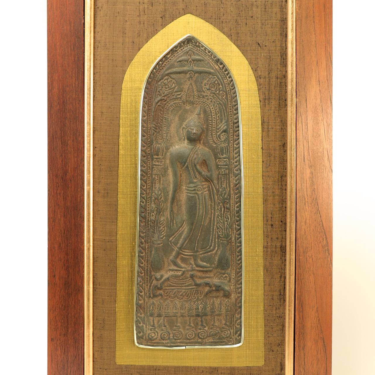Thai Buddhist votive plaque, Sukhothai style, cast in relief from a metal alloy of tin and lead with an iron like surface of a deep brown color, depicting a relief image of a walking Buddha. His left foot planted firmly on the ground while his right