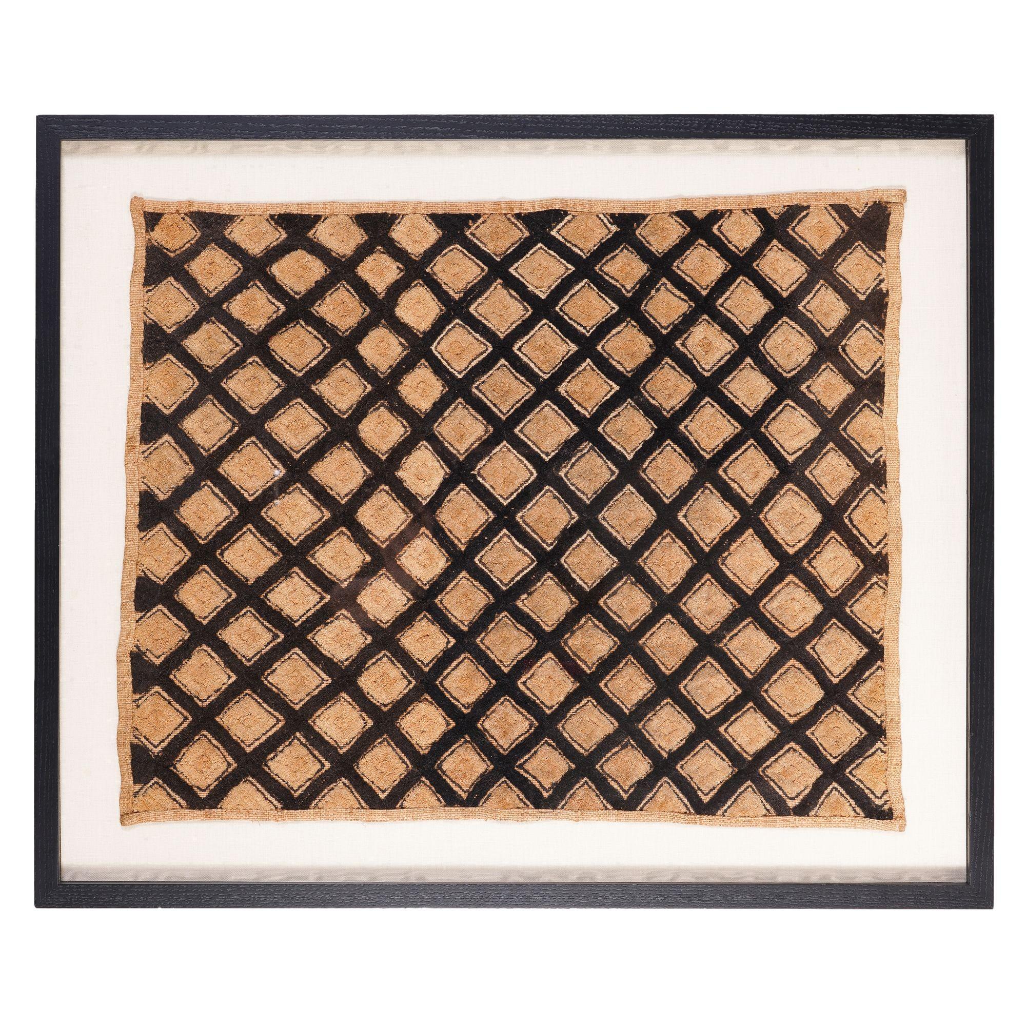 Westafrikanische Kuba-Stoffmatte, gewebt aus gefärbten und natürlichen Palmfasern auf Raffiabast-Grund, die in einem diagonalen Windelmuster zu einem einheitlichen Gesamtmuster verlegt sind. Archivpassepartout auf einer Stoffleinwand und gerahmt in
