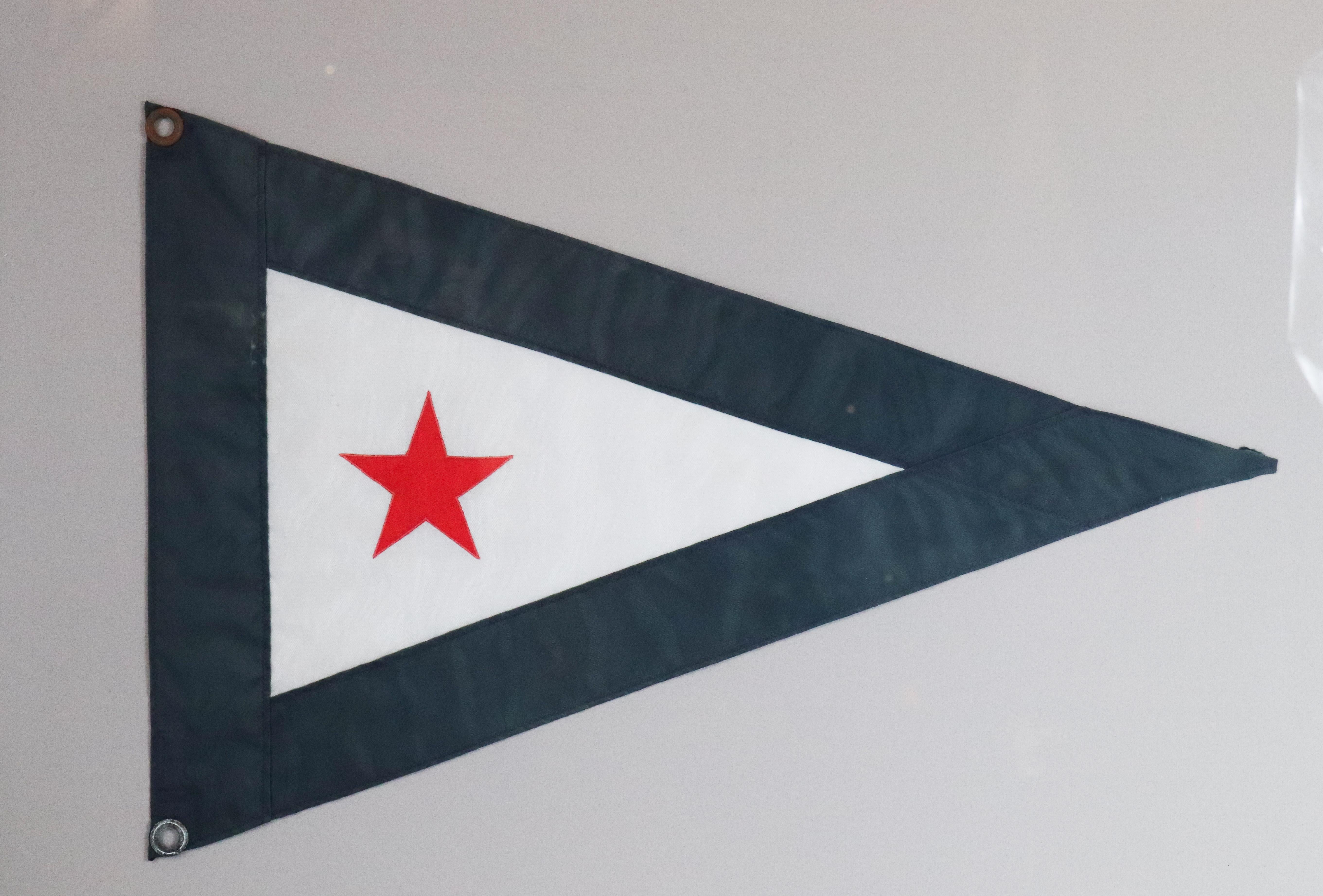 Red, white and blue burgee showing a red star on white field with blue border. Nicely framed with gray mat. 26