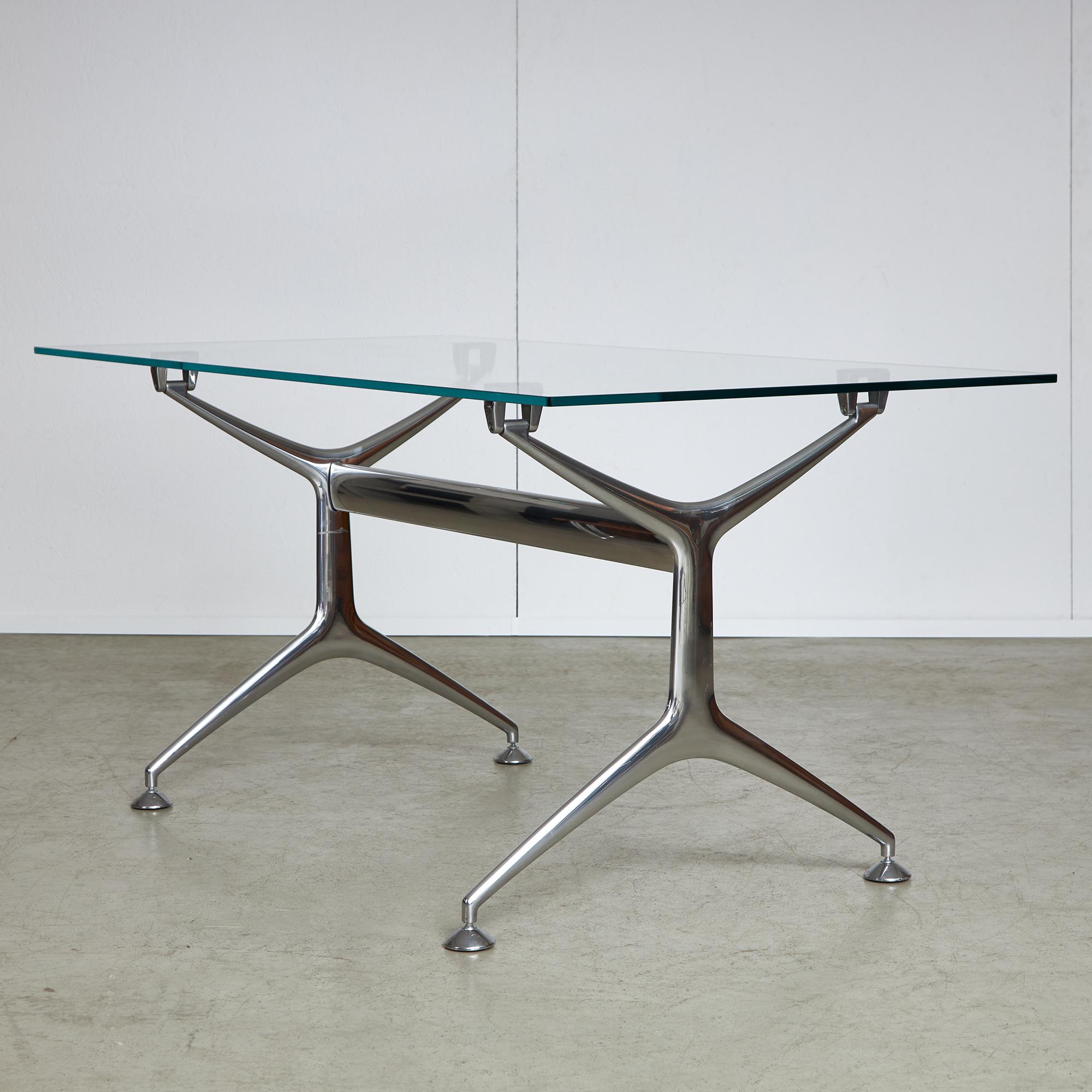Frametable designed by Alberto Meda for Alias in 2001. The table features an aluminum frame with a glass top. The item has a sense of formal lightness with its shiny frames and decorative elements such as the table legs and glass top holders. The