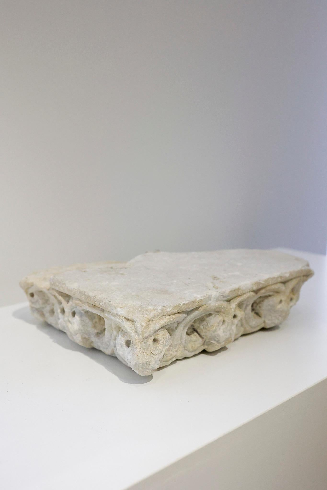 Frammento di cornicione in marmo di epoca romanica - XIII secolo.
Il frammento presenta una decorazione scolpita con motivi vegetali stilizzati che potrebbero ricordare le foglie d'acanto, disposte in volute e intersecate da forme tondeggianti che