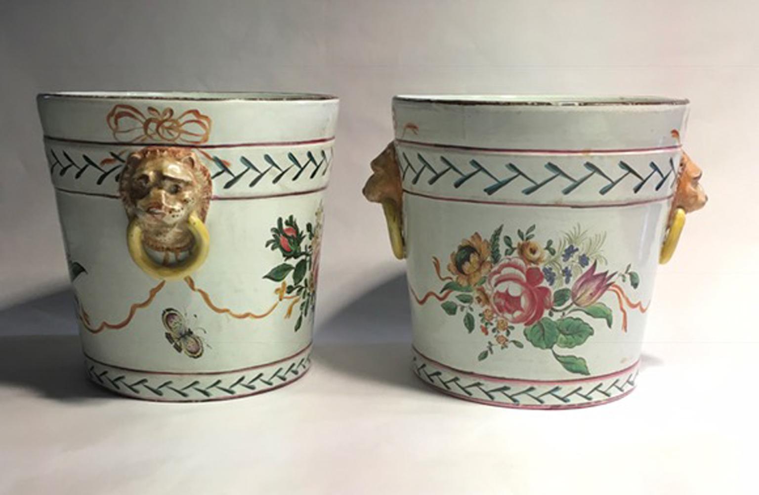 Paire de cache-pots en poterie de la fin du XIXe siècle en France avec des fleurs et des têtes de lions. 

Cette paire de beaux vases, est un cache-pot très décoratif, avec un couple de têtes de lions comme poignées.
Des bouquets de roses courent