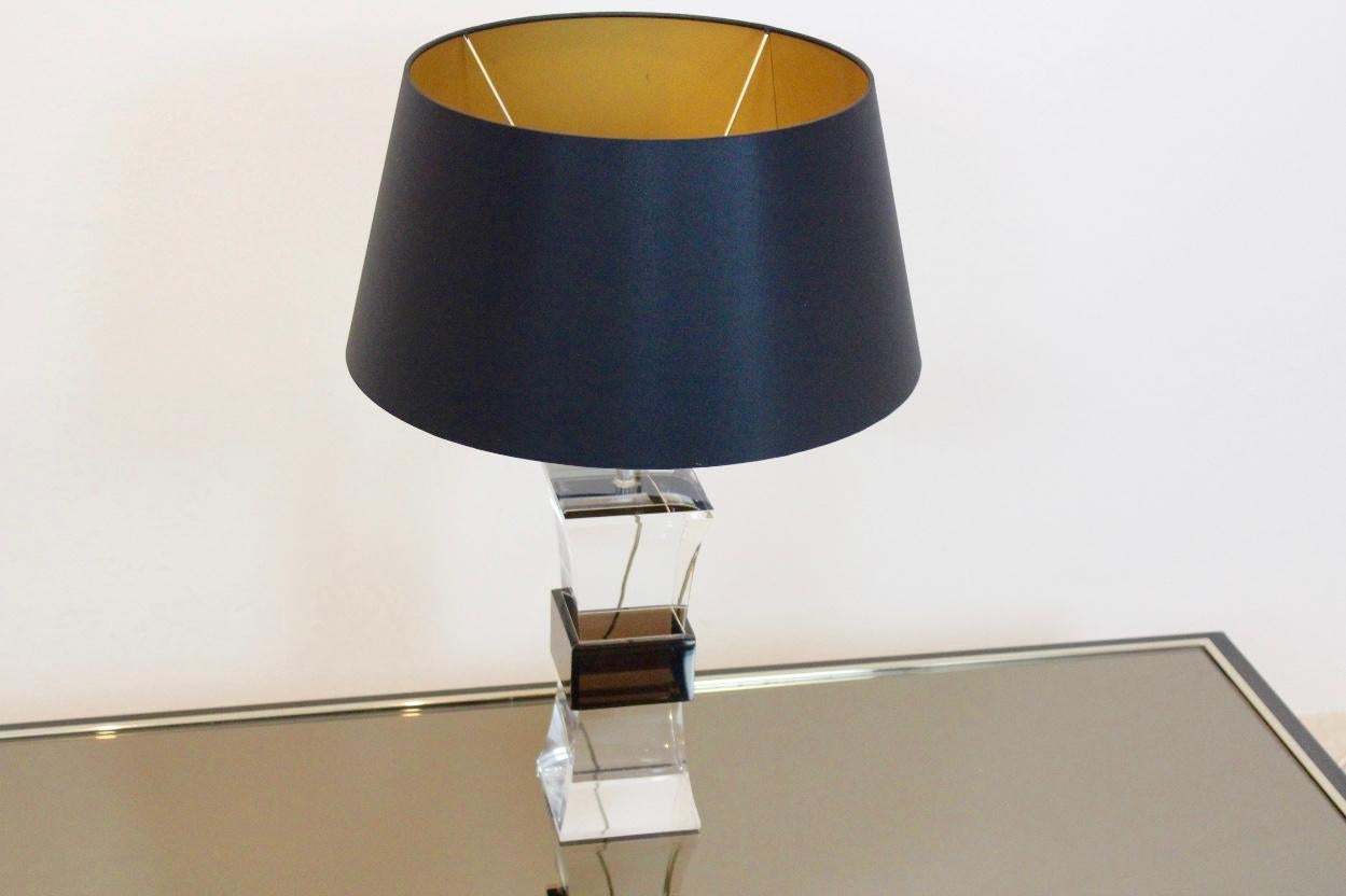 Unique et magnifique lampe de table en Lucite datant des années 1970. La lampe est composée de deux couleurs de Lucite, l'une transparente et l'autre d'un brun chaud entourant la partie transparente. Fabriqué en France et d'aspect sophistiqué, il