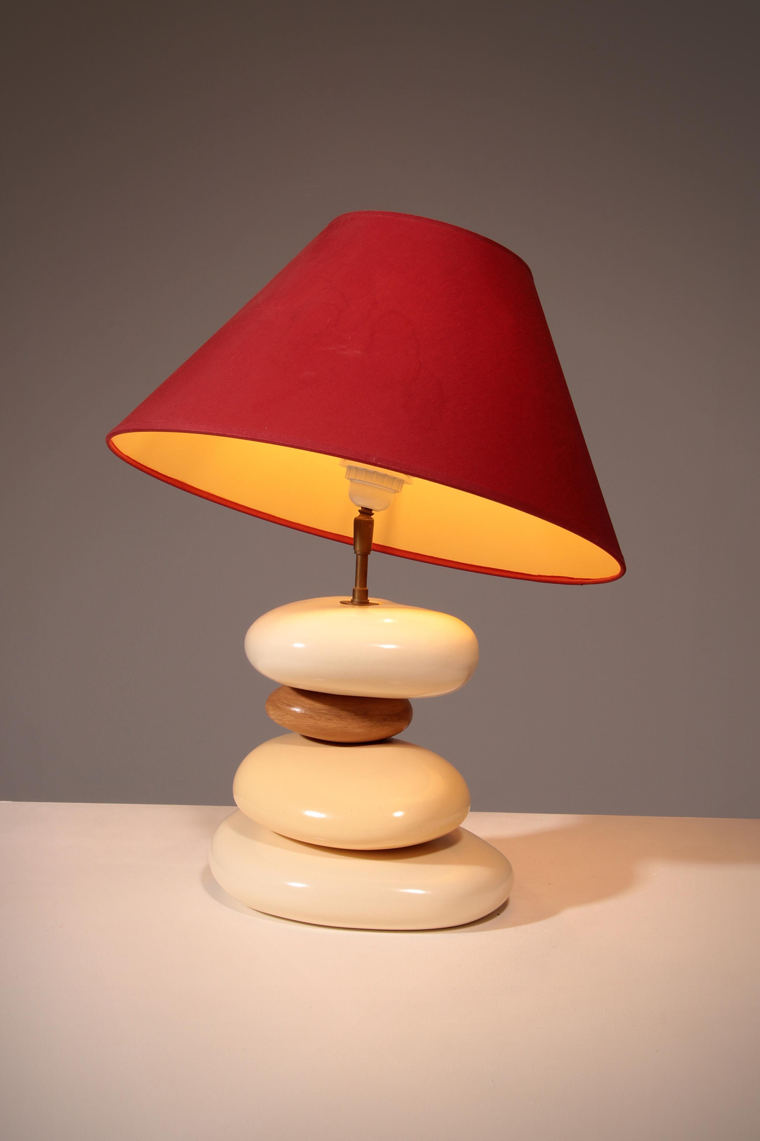 

This rare 1980s François Chatain Pebble table lamp is a striking example of French artistic lighting design. Its sculptural base, formed by four handcrafted ceramic pebbles in soft cream and warm off-white tones, captures the organic elegance that