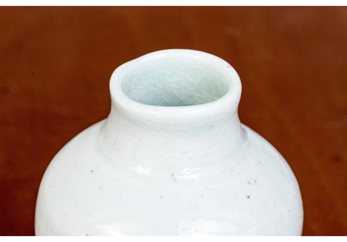 Frances Palmer signed diminutive baluster form vase with a circular foot, wide shoulders and a cylindrical neck. The vase with a fine crackle glaze finish in a very pale green shade. Signed on verso. Applied green felt pads on bottom.

Dimensions: 5
