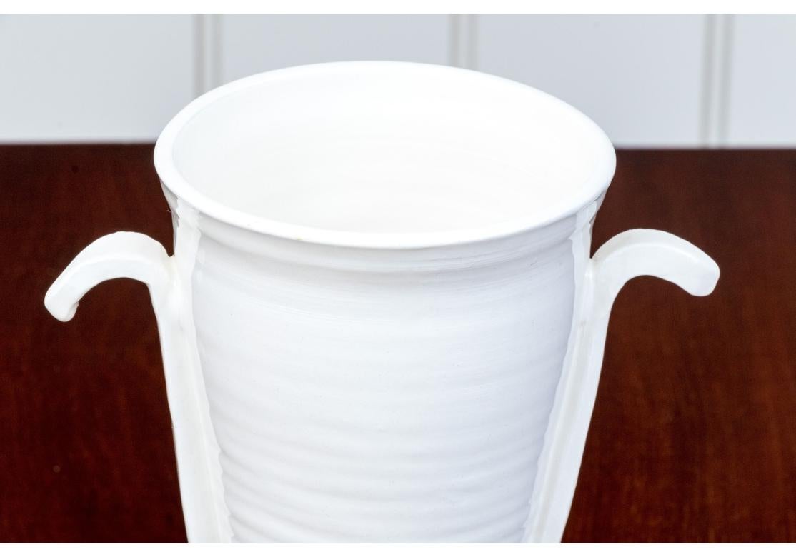 Vaso di terracotta smaltata color crema con piede di Frances Palmer con vaso a coste affiancato da manici curvi. Il vaso è firmato e datato 2019 sul verso.

Dimensioni: 11 3/4