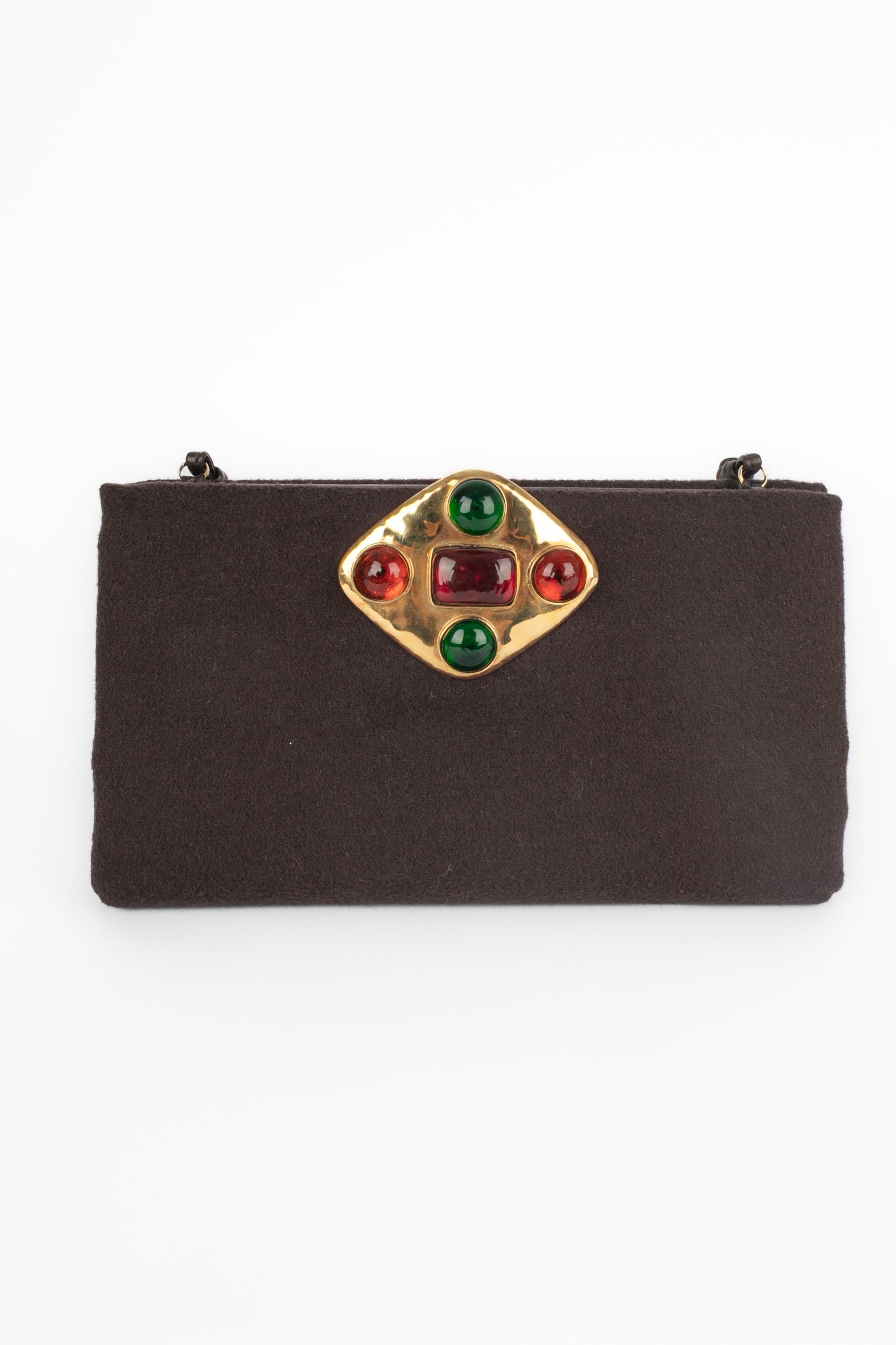 FRANCES PATIKY STEIN - Handtasche aus brauner Wolle. Goldener Metallverschluss, verziert mit roten, grünen und orangefarbenen Cabochons aus Glaspaste. Dünner Ledergriff.

Bedingung:
Sehr guter Zustand

Abmessungen:
Länge: 22 cm - Höhe: 13 cm -