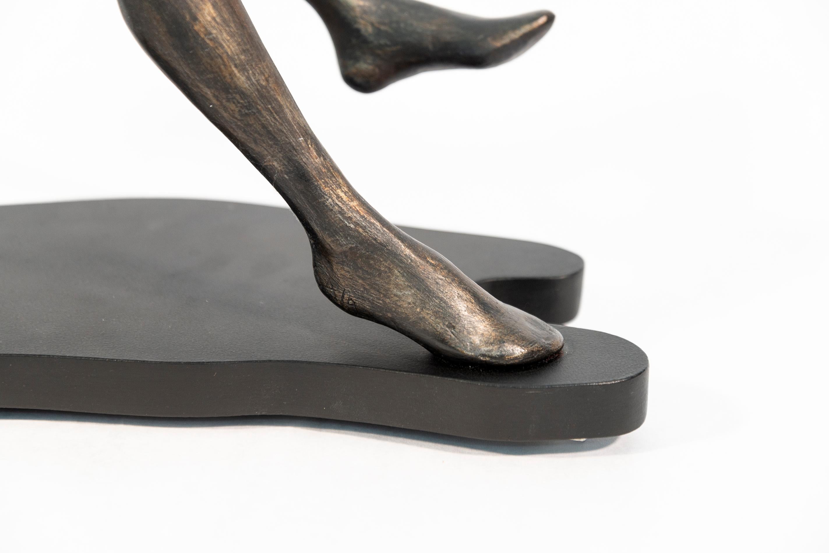 Les sculptures de Frances Semple, belles et élégantes, semblent souvent en mouvement. Défiant la gravité, une figure horizontale semble flotter sur le dos au-dessus de son ombre. Ce plateau de table est fabriqué en résine et repose sur une base en