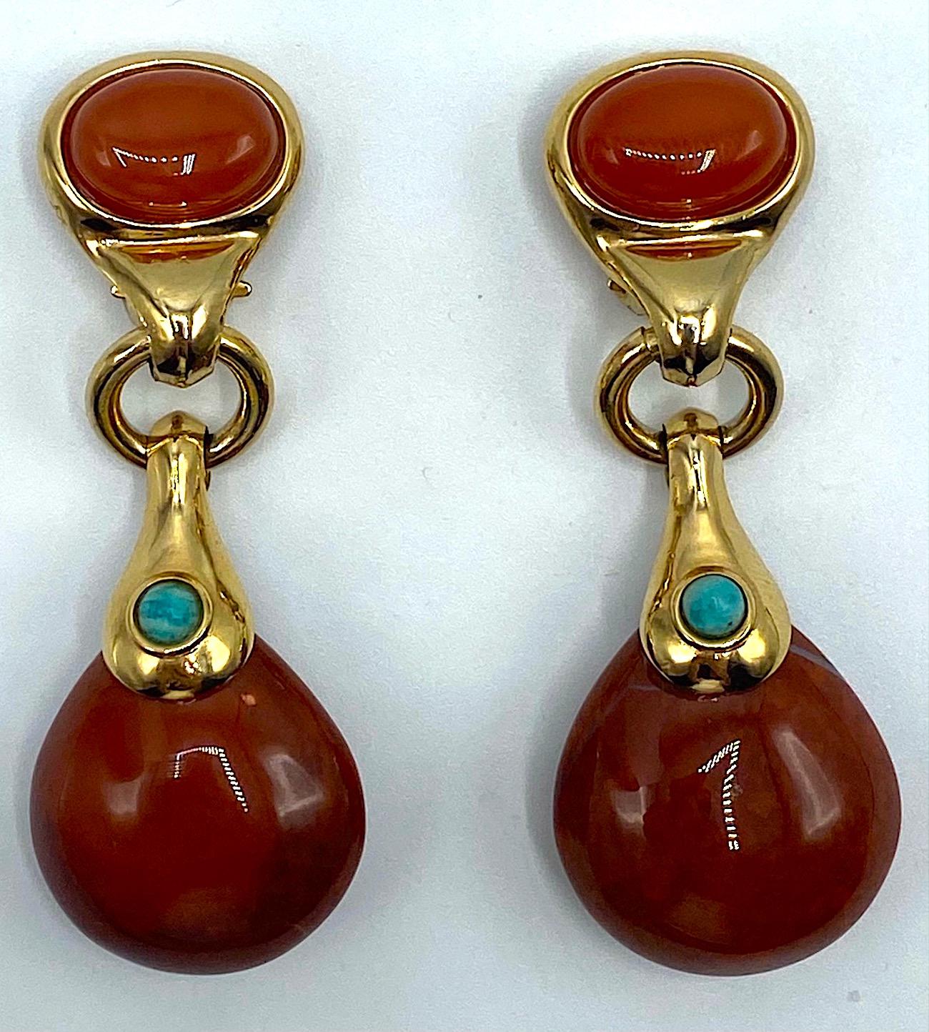 A pair of 1980s pendant earrings from Italian fashion jewelry designer Francesca Romana. They are gold plated with the tops set with an oval carnelian color glass cabochon. Suspended from a half inch diameter ring is a polished natural pear shape