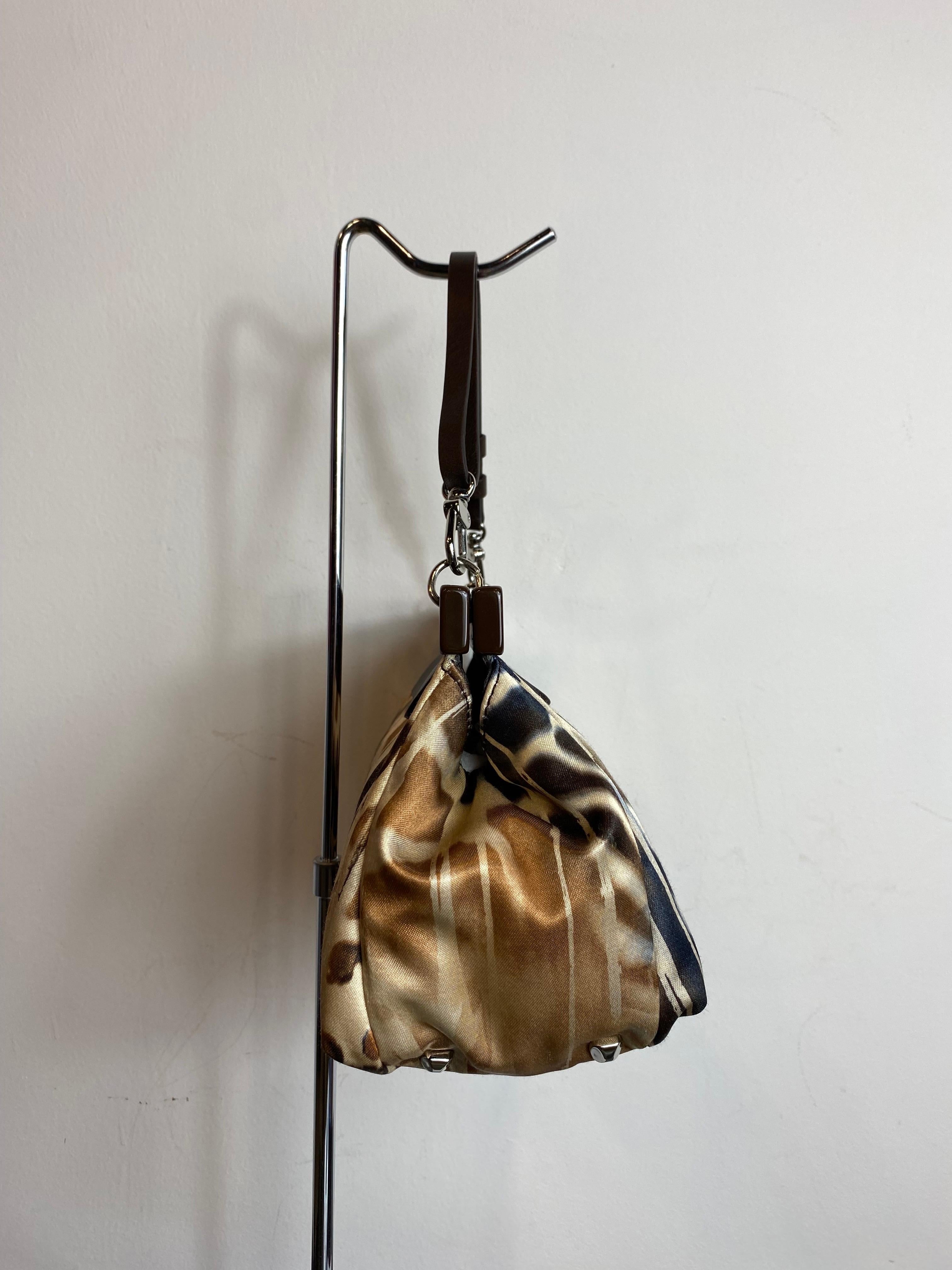 Francesco Biasia handbag with brown animal pattern, in satin and leather details. With rigid clutch closure. 
Inside it is lined and has a zip pocket. 
It has a small sign of wear on the clasp as in the photo but it is practically as good as new.