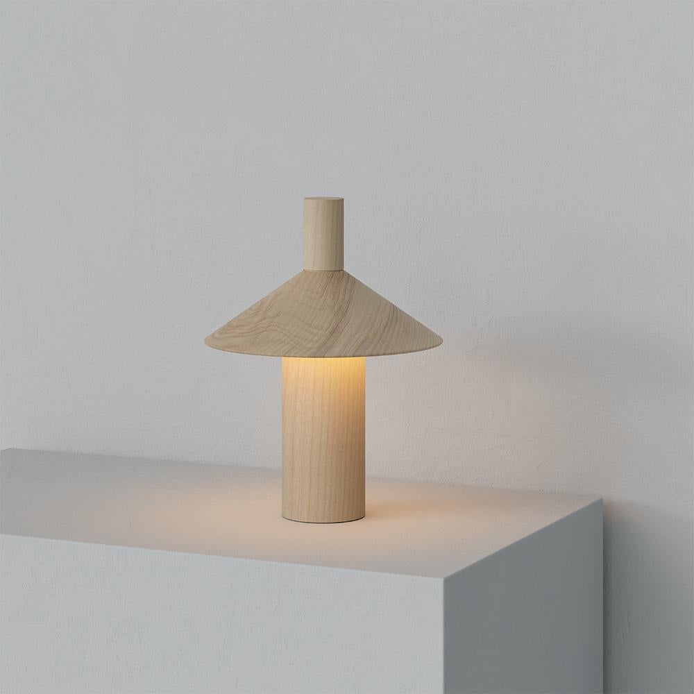 Lámpara de mesa portátil 'Pepa' de Francesco Faccin en madera maciza de fresno para Astep. 

Con un robusto cuerpo de madera maciza de fresno y alimentado por un corazón tecnológico, Pepa se inspira en la refinada sencillez de los pimenteros de la