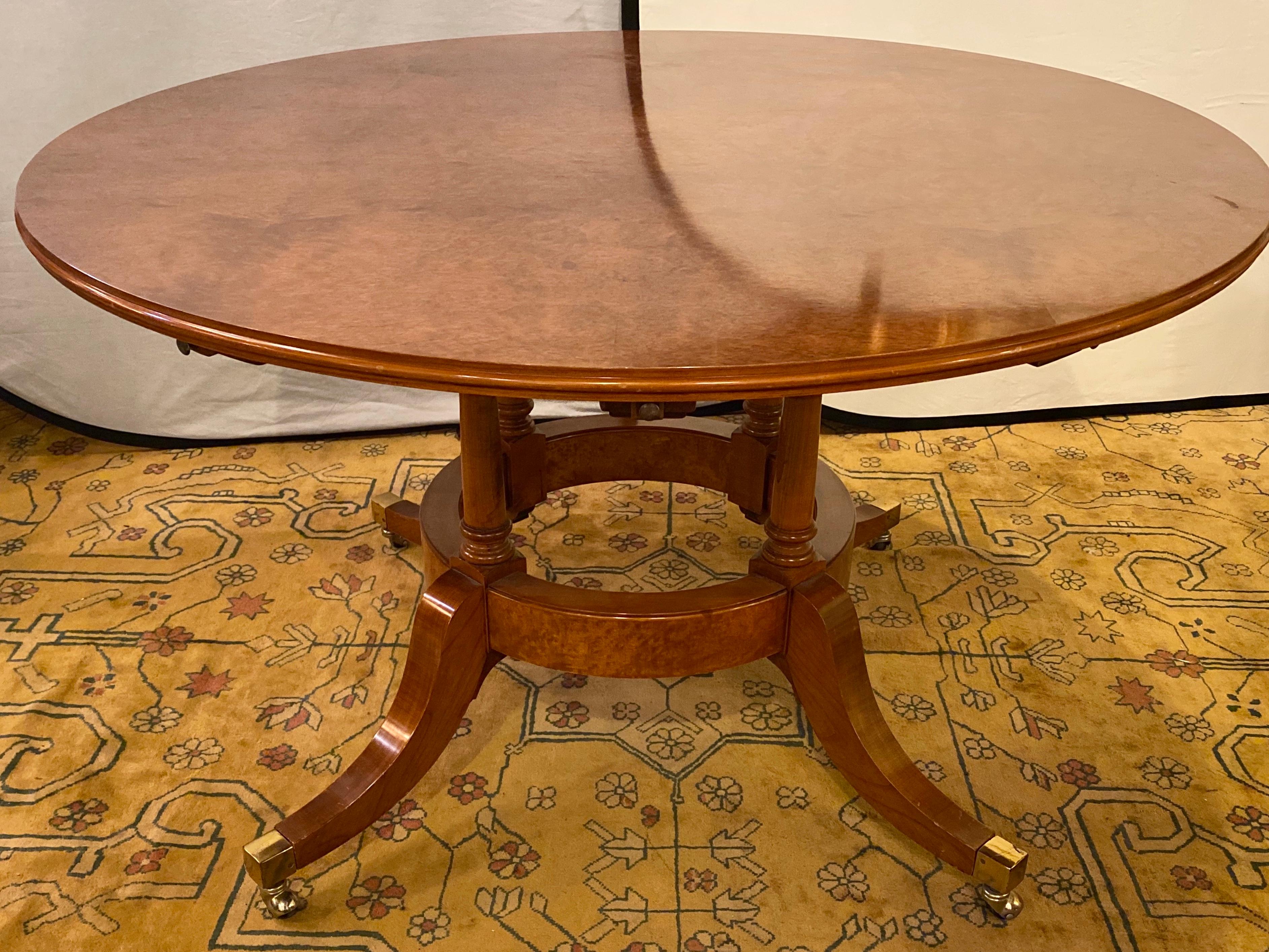 Francesco Molon Regency style dining center table by Giemme. Spectacular tortoise finished tabletop set on quad legged base having extension leafs measuring 11 inches each. The whole supported by brass casters on strong easy to move wheels. The
