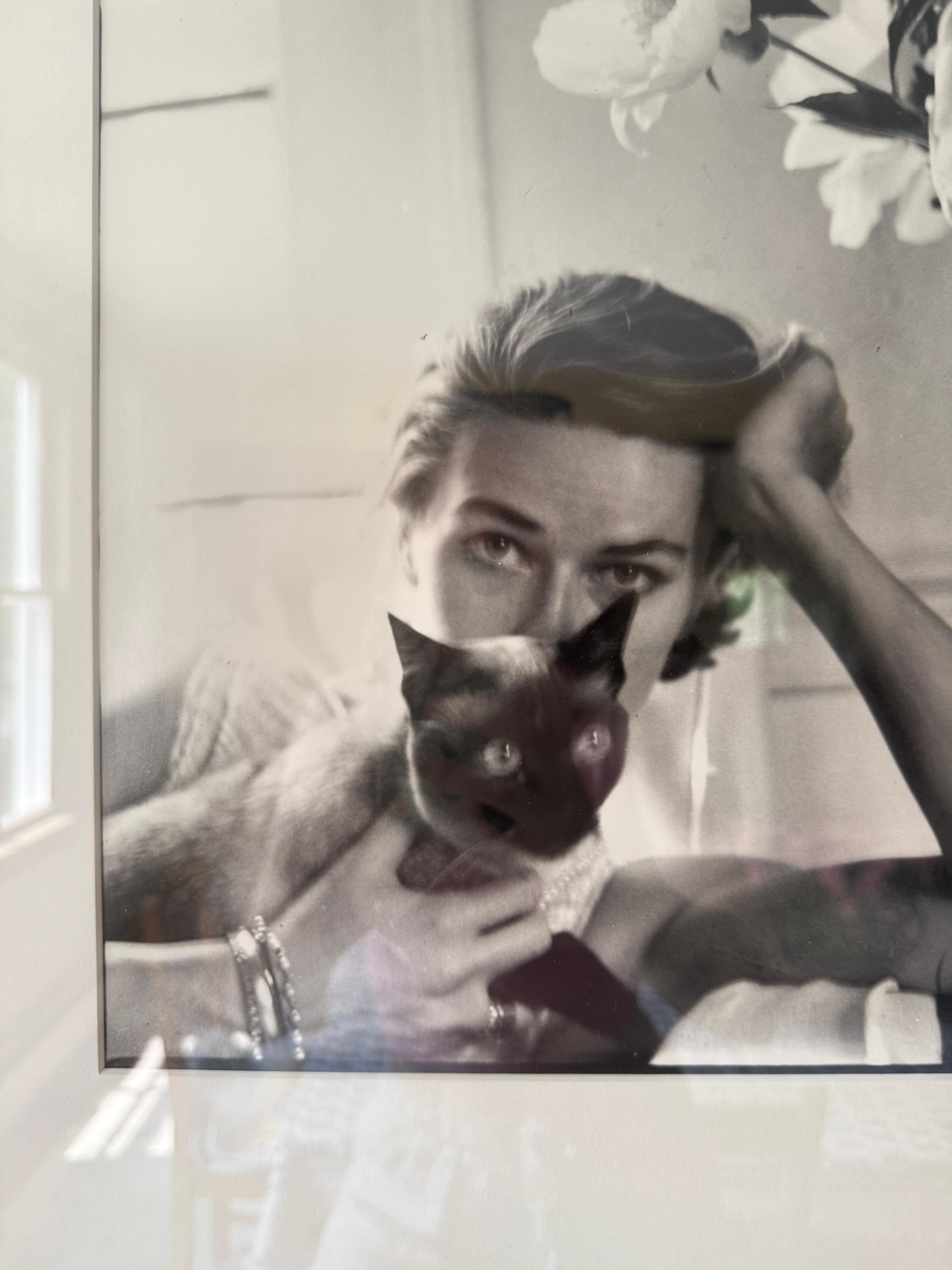 A black and white photograph of the artist's wife, fashion model, Caroll McCallson, and their cat in their home in East Hampton. Matted and framed under glass. 


