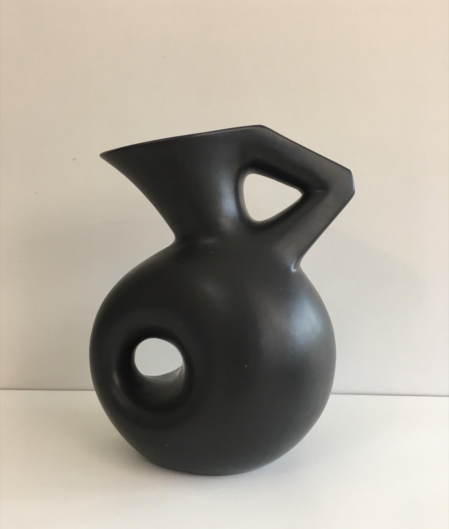 Francis Cova. This tall black ceramic sculpture is a pitcher which represents a stylized woman. This piece is signed with a tag. This is a French very interesting work, circa 1970.
  