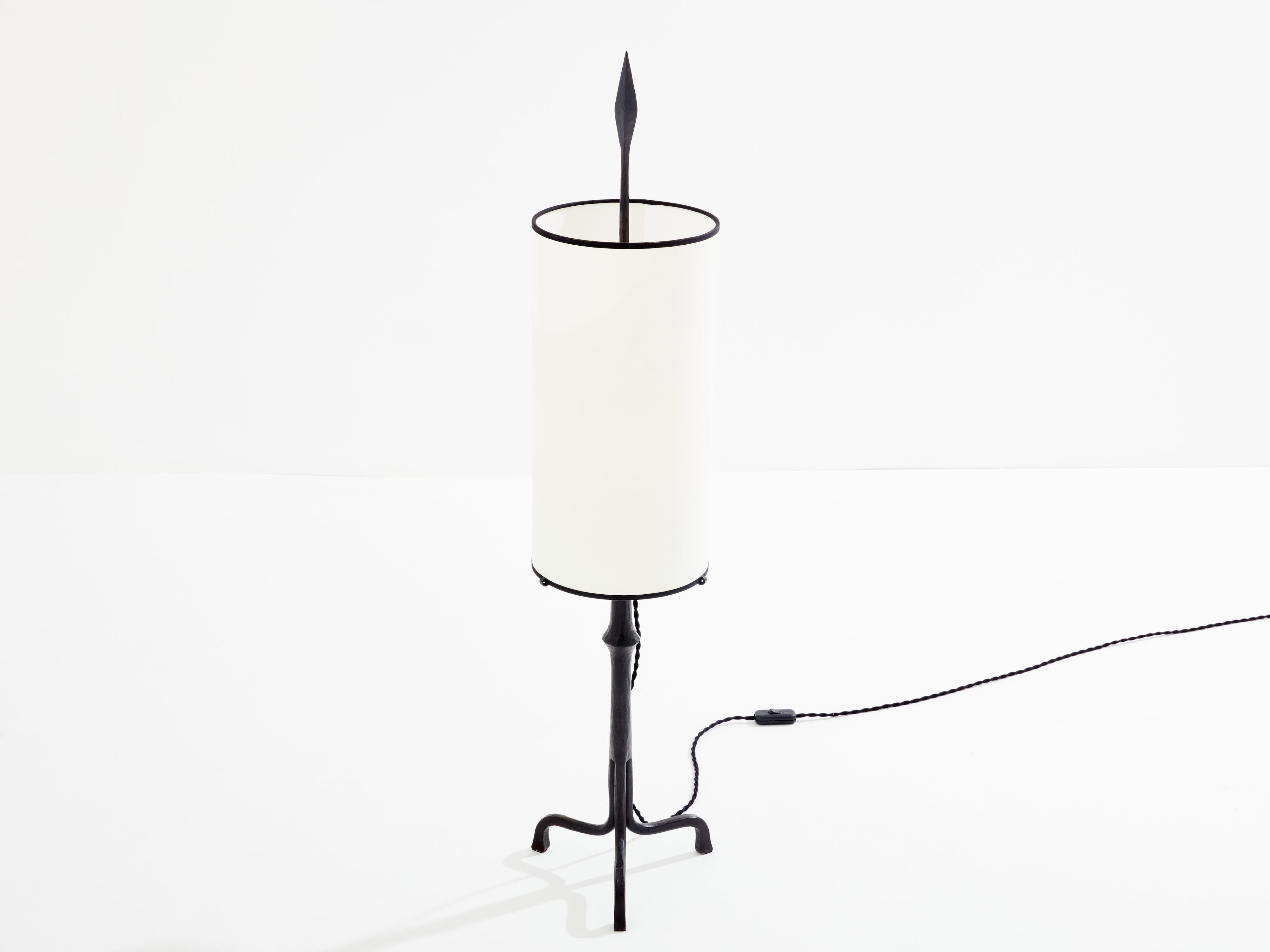 Esta lámpara es una rara pieza de hierro forjado de 1955, creada por Francis Dewaele para Les Artisans de Marolles bajo la dirección de Jean Touret. Se distingue por su diseño elegante y minimalista, con una base de hierro forjado de líneas limpias