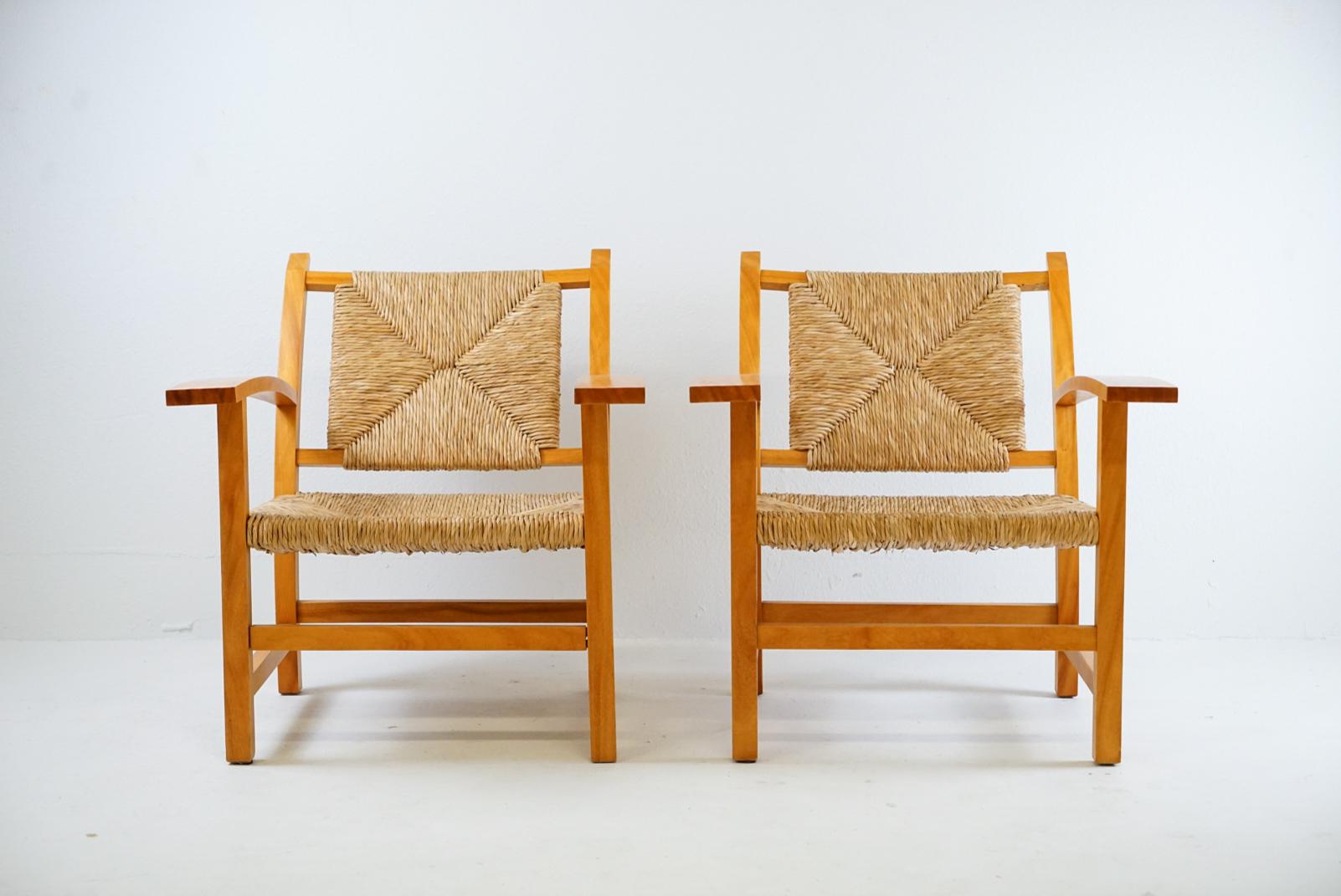 Beautiful Vintage French arm chairs attributed to Francis Jourdain. 

Beech frame with patina and excellent condition woven rush seat and back. 
Acquired from architect who purchased in France 50 years ago and always kept indoors in his library.