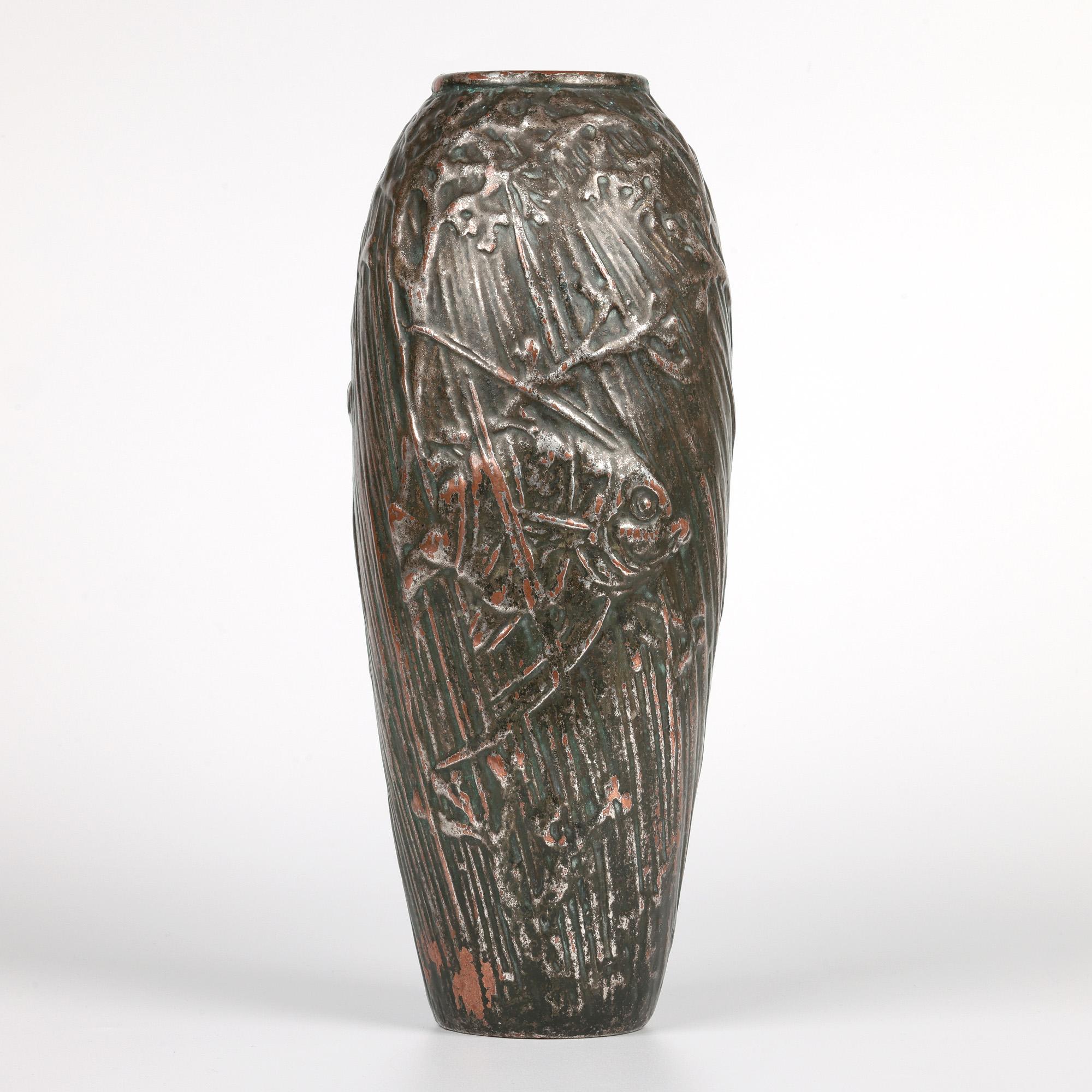 A rare and stunning Doulton Lambeth copper clad art pottery vase decorated with fish swimming amidst weed by renowned artist Francis C Pope and dating from the early 20th century. The tall stoneware baluster shaped vase is clad in copper which has a