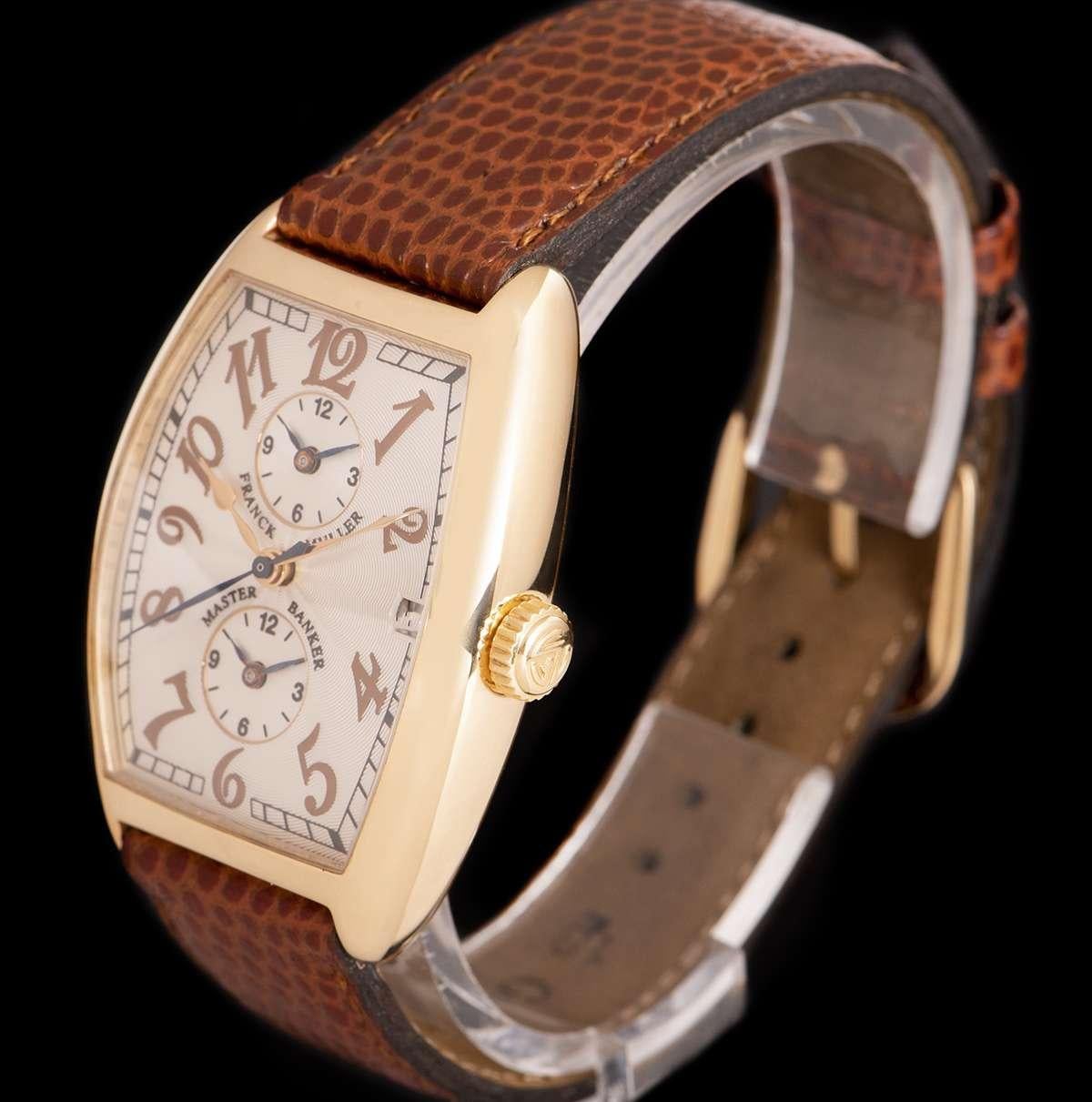 An 18k Rose Gold Master Banker Gents Wristwatch, silver guilloche dial with applied arabic numbers, date at 3 0'clock, 2 additional time zone dials at 6 0'clock and 12 0'clock, a fixed 18k rose bezel, a brand new brown leather strap with an 18k rose