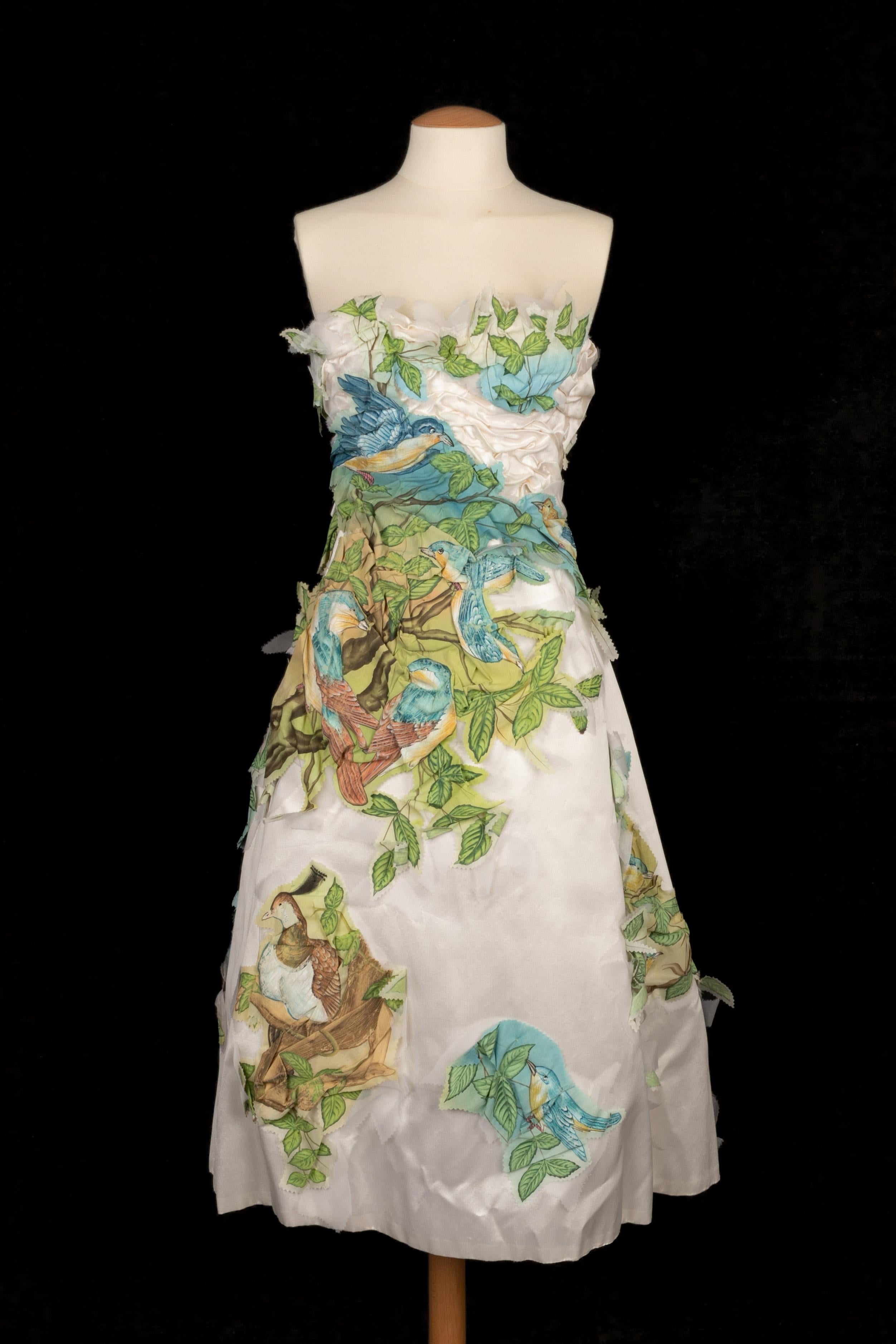 FRANCK SORBIER - Abito bustier in seta bianca sovrapposto a un tessuto con motivi di fiori e uccelli dipinti a mano. Non è indicata la taglia, si adatta a una 34FR/36FR. Collezione Haute Couture Primavera-Estate 2014.

Condizioni:
Ottime