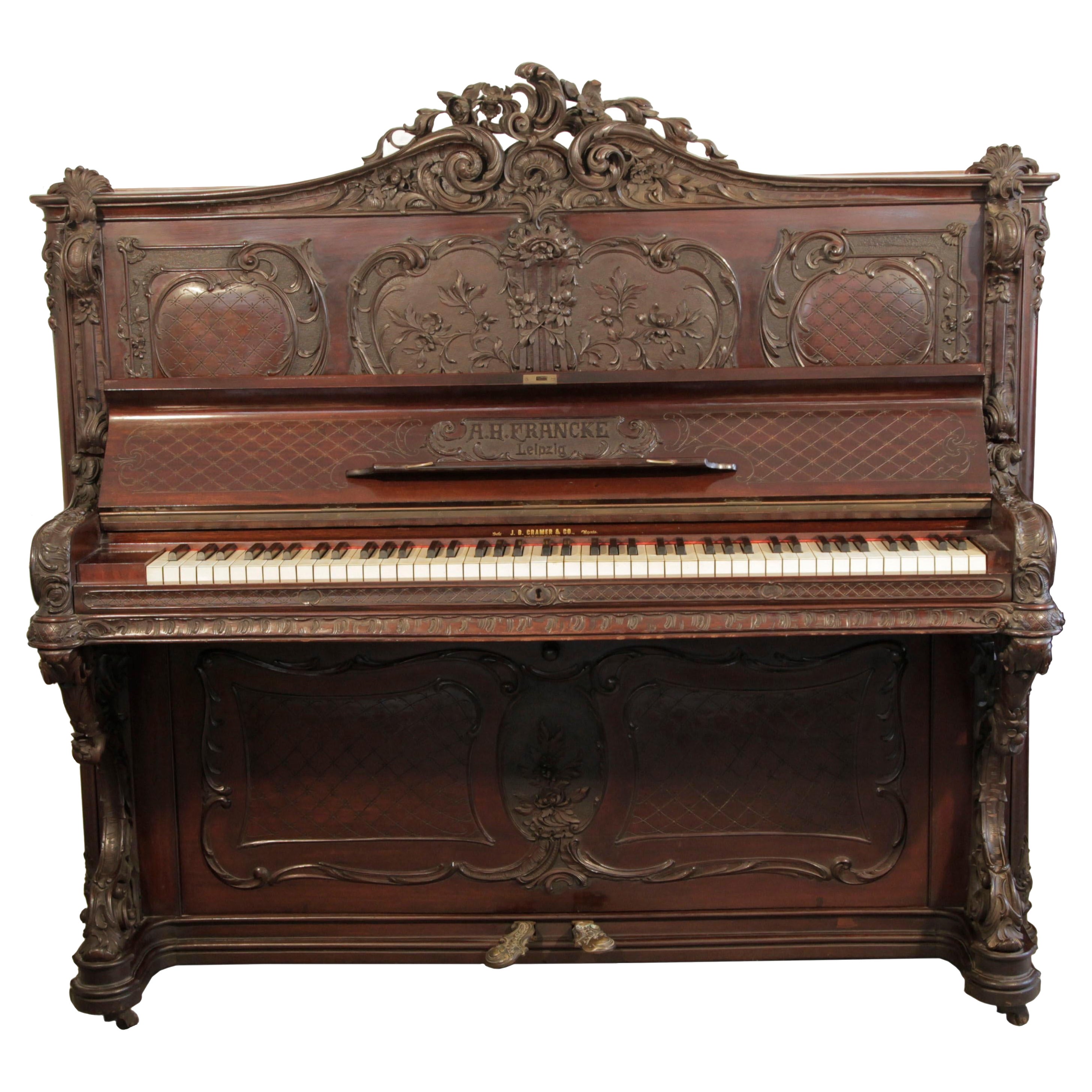 Francke Piano droit de style rococo Acajou sculpté Pieds à rouleau en haut-relief