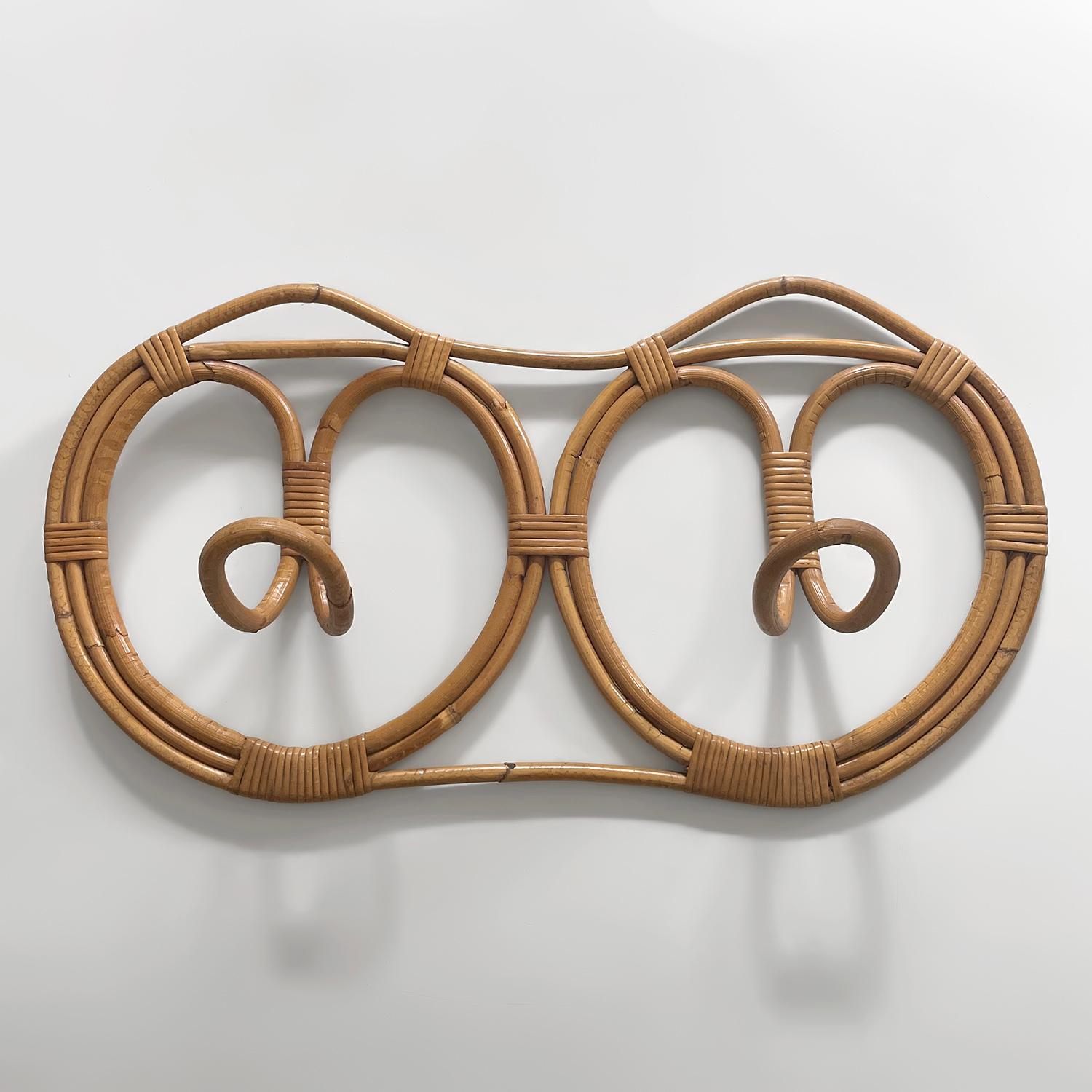 Franco Albini and Franca Helg rattan coat rack
Italy, circa 1960s
Italian mid century craftsmanship at its finest
This wall mounted piece provides ample storage with two circular rattan coat hooks 
Light yet very sturdy and feels like a work of