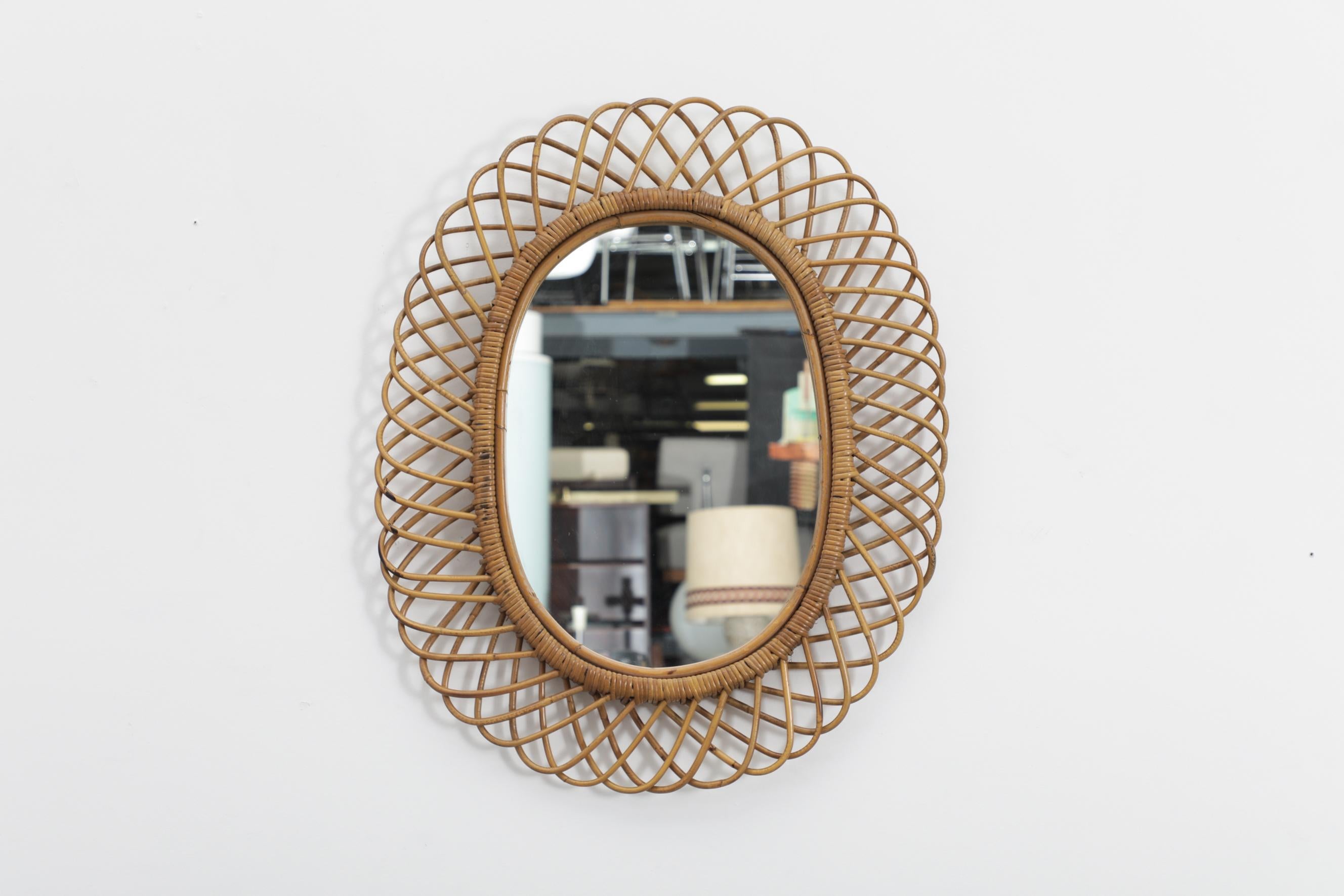 Woven bamboo framed mid-century mirror. Hand made and delicately shaped. Three available, all in similar original condition with minimal wear and breakage., consistent with their age and use. The mirror without the frame measures 13.875 x 20. Other