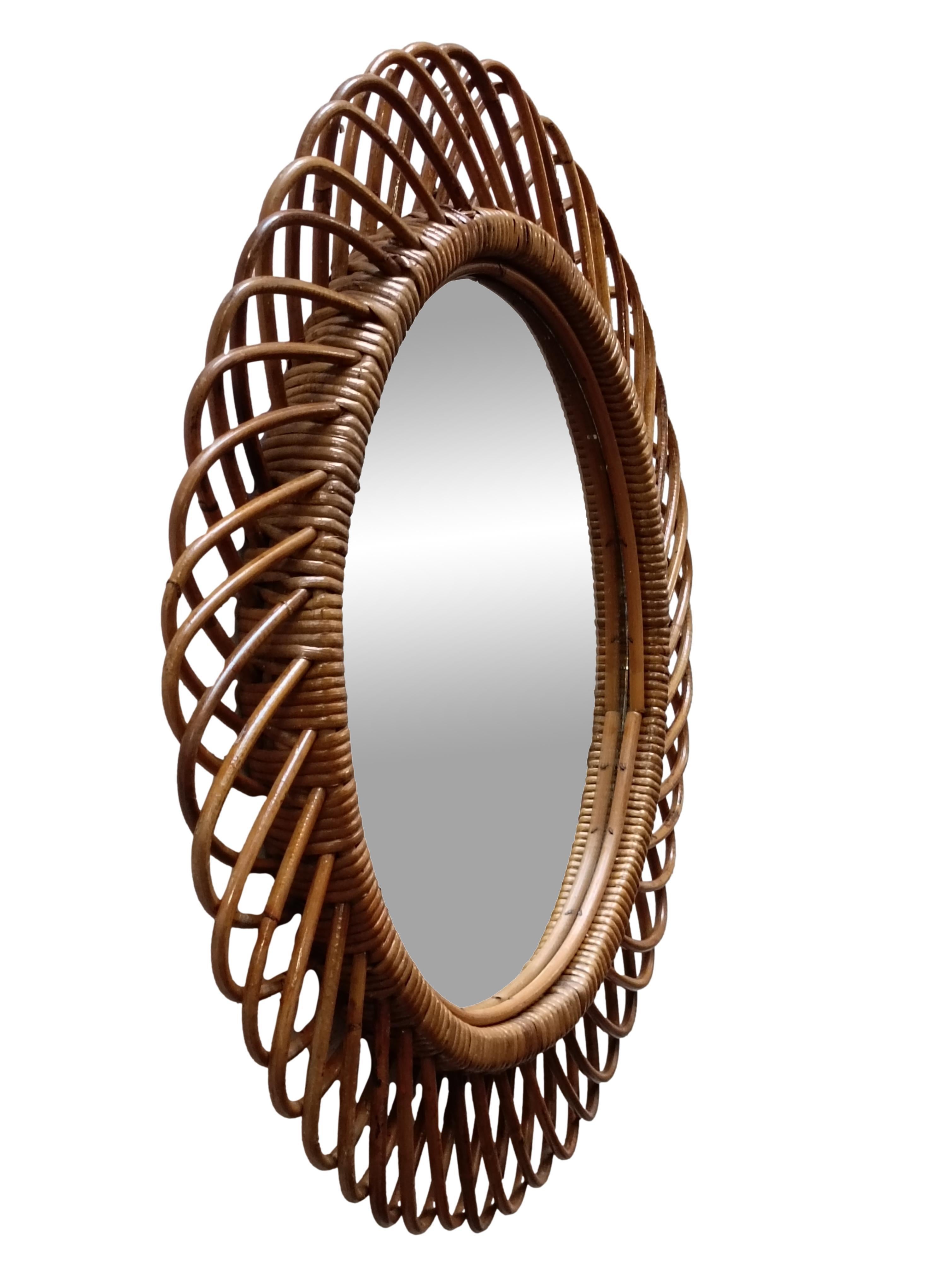 Specchio da parete, realizzato in Italia, anni '50. Il vetro a specchio tagliato è incorniciato in bambù e rattan.
