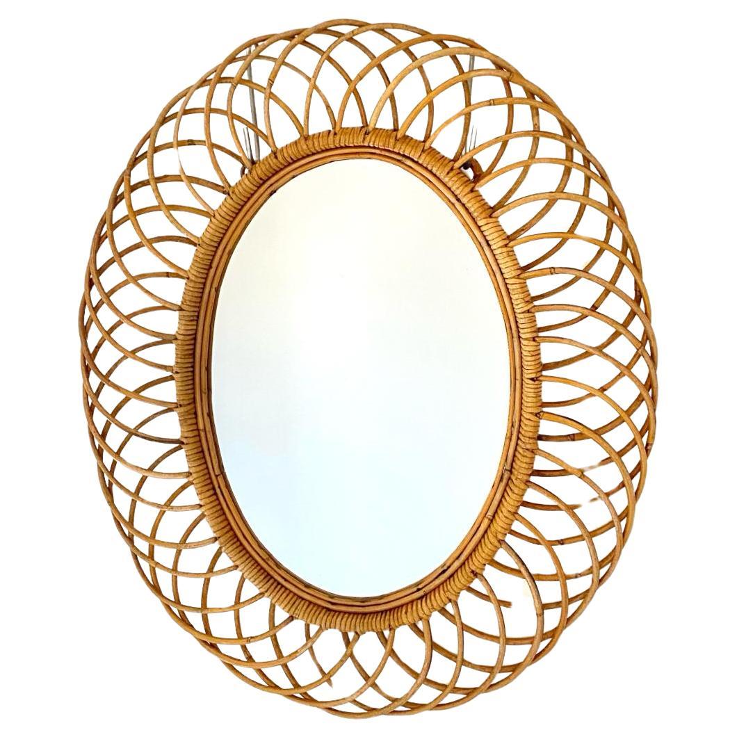 Espejo de bambú y ratán Franco Albini para Bonacina Sunburst 

Elegante espejo sunburst de bambú de los años 60. Forma ovalada con marco compuesto de anillos de bambú finamente entrelazados. En muy buen estado, con leves signos del paso del tiempo.