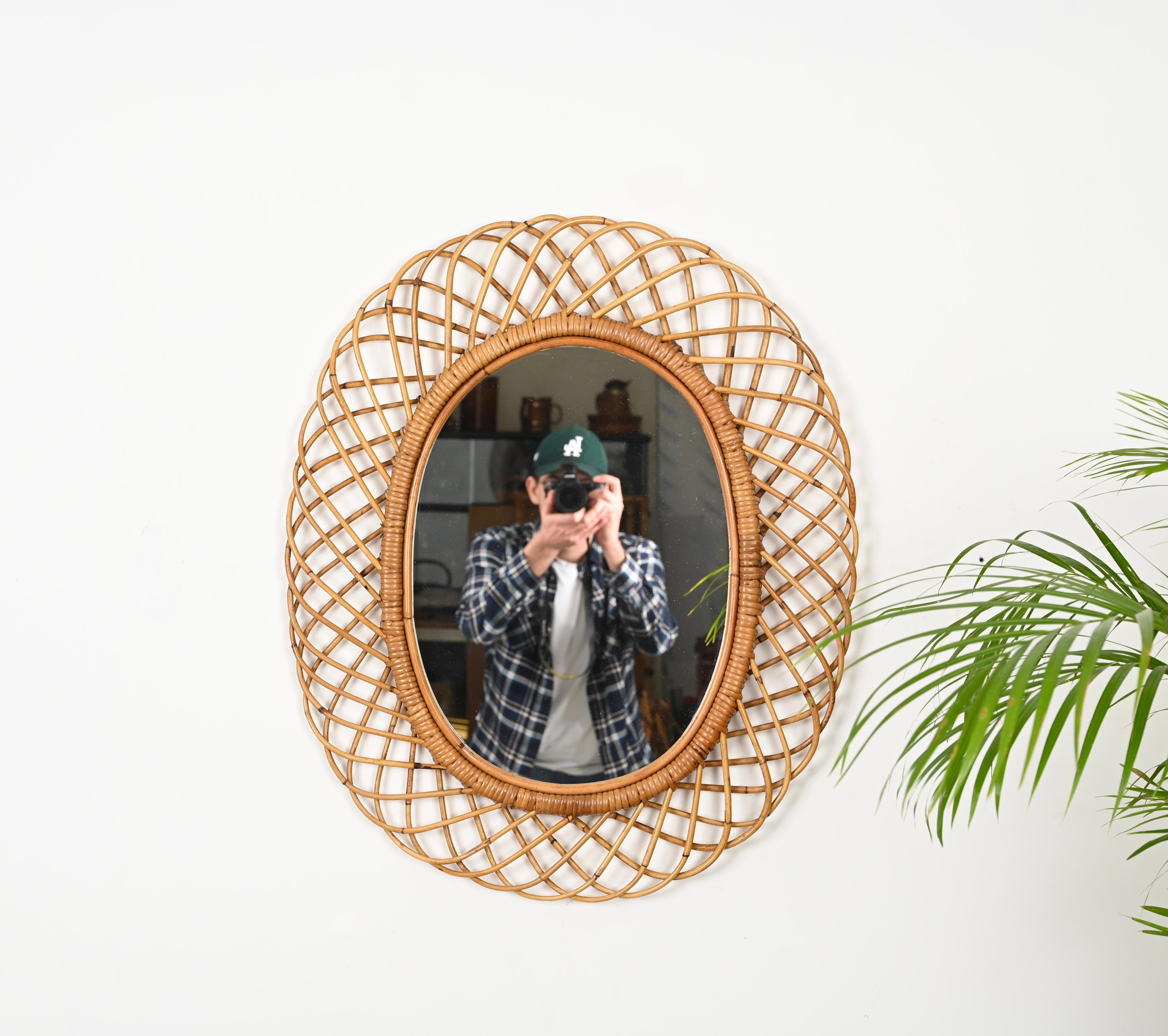 Magnifico specchio ovale della Costa Azzurra di metà secolo in rattan curvato, bambù e vimini. Questo splendido pezzo è stato prodotto in Italia negli anni Sessanta.

Questo specchio decorativo ovale è unico perché ha una splendida trave in rattan