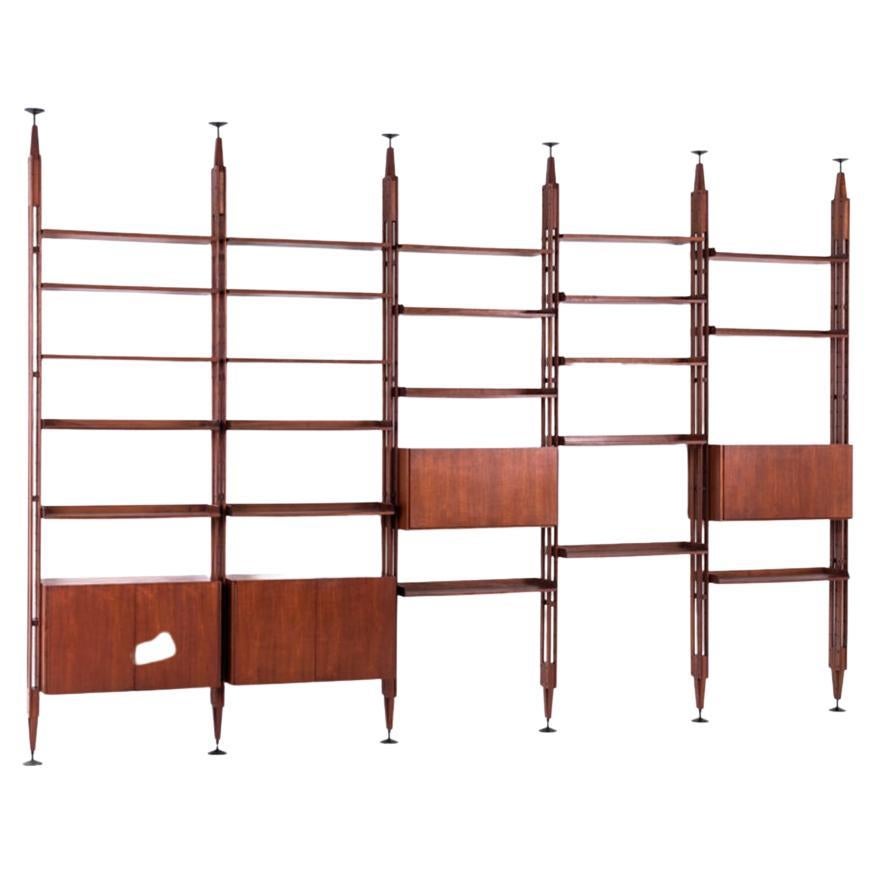 Franco Albini (1905-1977)

Infinito original Bucheinheit. Großes modulares Bücherregal, bestehend aus 6 vertikalen Stützen, Containerelementen mit Flügeltüren und unteren Türen mit 28 Tek-Holzböden und 2 Minitischen. Scheibenförmige Metallfüße,