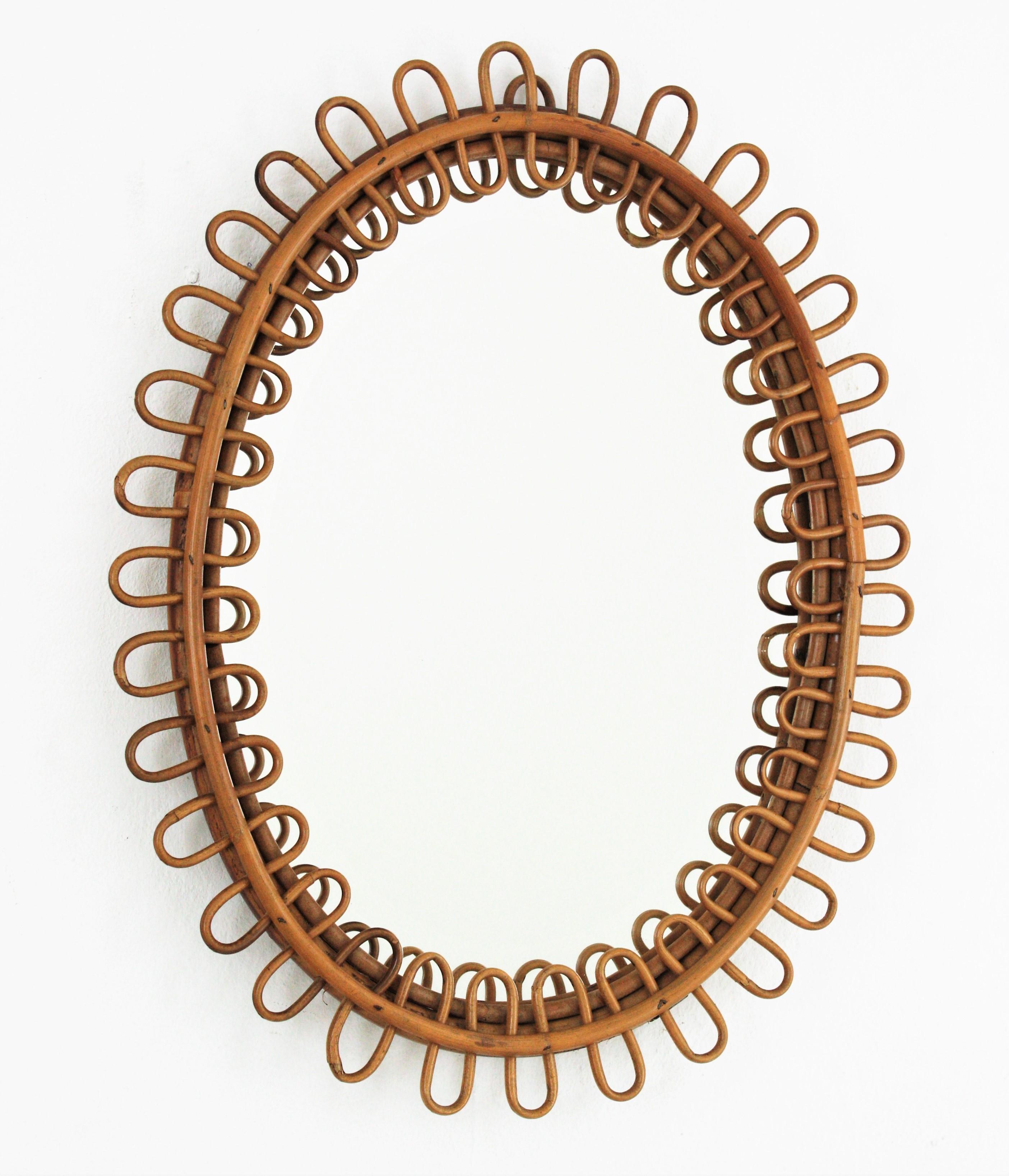 Miroir ovale très décoratif de style moderne du milieu du siècle avec cadre en rotin ondulé attribué à Franco Albini:: Italie:: années 1950. 
Très beau placé seul:: mais aussi magnifique exposé avec d'autres miroirs cannes dans une décoration