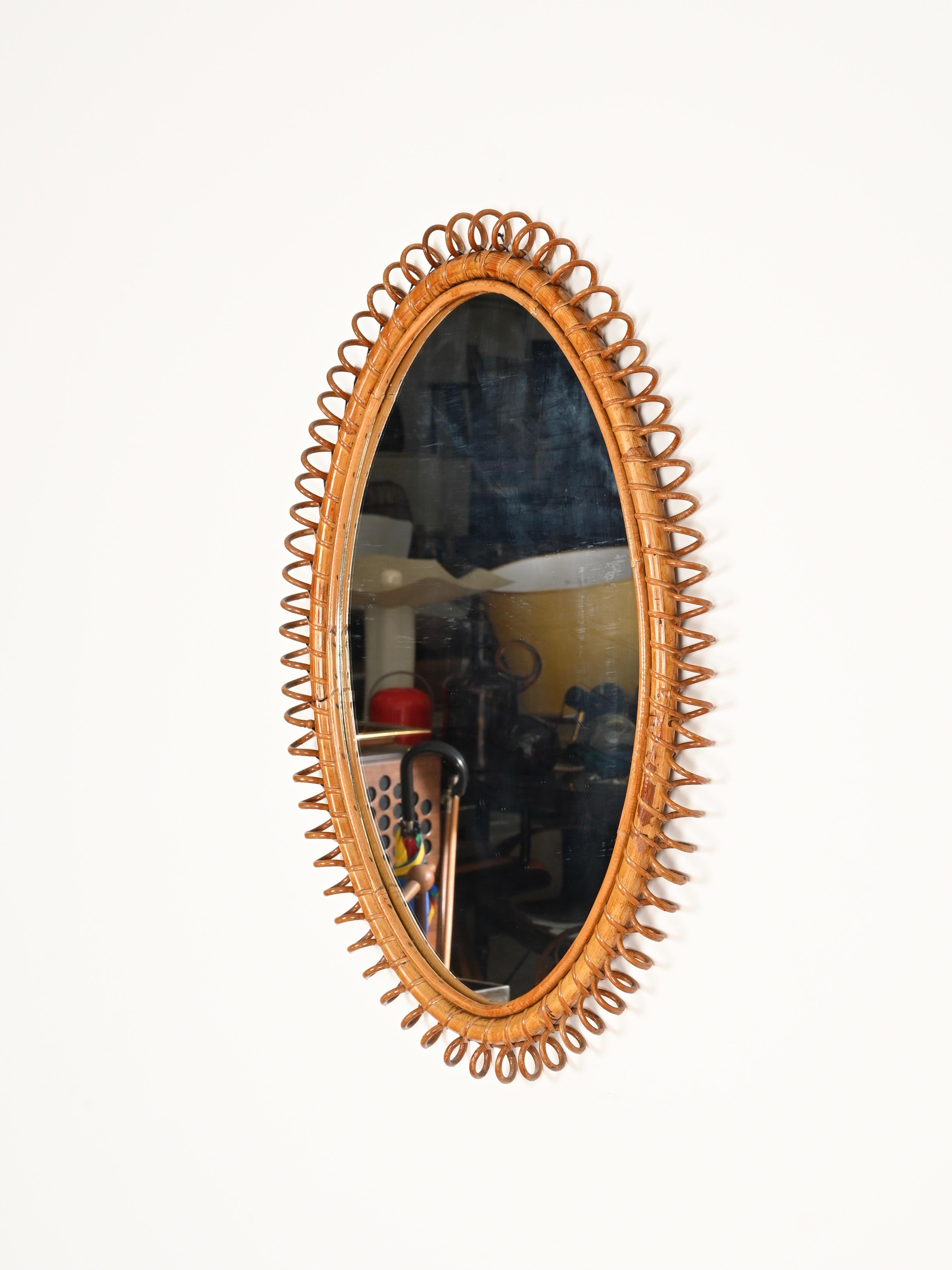 Meraviglioso specchio ovale di grandi dimensioni del Mid-Century realizzato interamente in bambù, rattan curvo e vimini intrecciato a mano. Questo specchio in stile Costa Azzurra, incredibilmente affascinante, è stato disegnato da Franco Albini e
