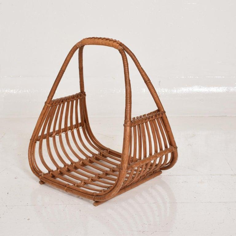 Mid-Century Modern Italian magazine rack holder basket attributed to the design of Franco Albini.
Handcrafted sculptural shape woven rattan with leather trimmed handle.
Made in Italy, circa 1960s.
Unmarked with attribution to Franco