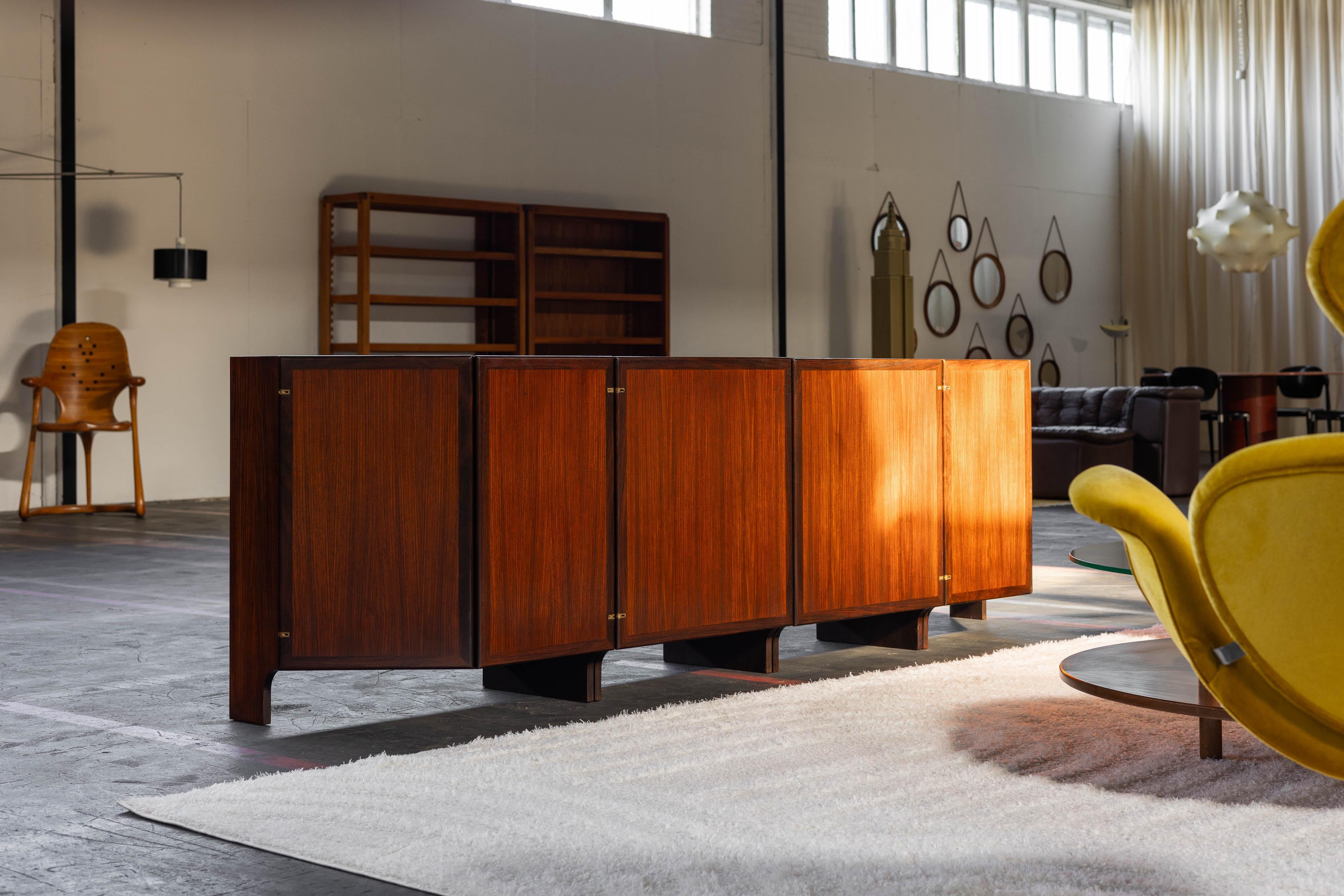 Te presentamos el excepcional aparador grande Franco Albini MB48, una obra maestra atemporal diseñada en 1963 para Poggi Italia. Este aparador, que forma parte de una icónica serie modular del renombrado diseñador Franco Albini, no sólo es una pieza