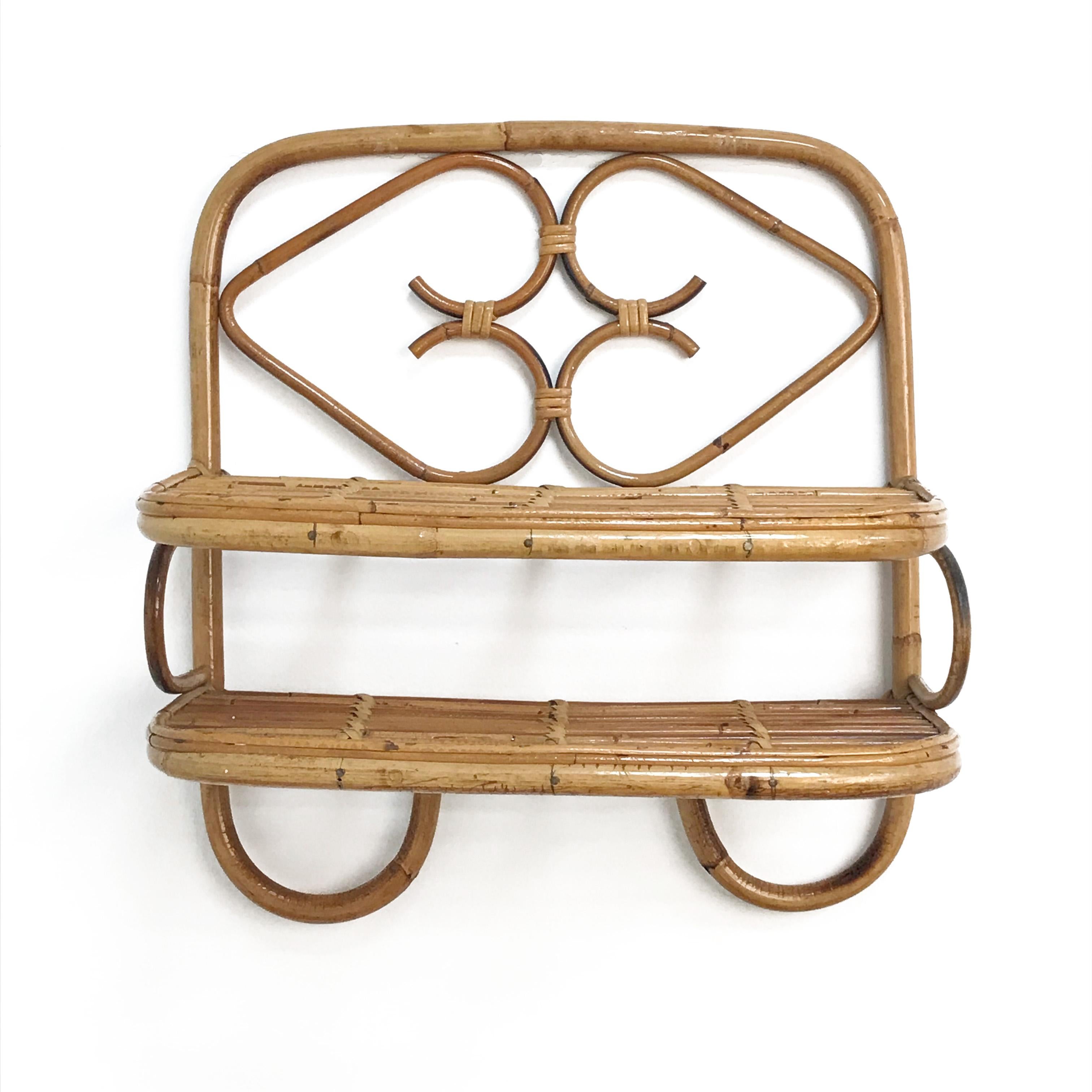 Amazing midcentury bamboo and rattan shelf or hanging side table. This wonderful piece was produced in Italy during 1960s.

This elegant item is unique as it has two rattan shelves with two hearts decorating the top one.

A multipurpose shelf that