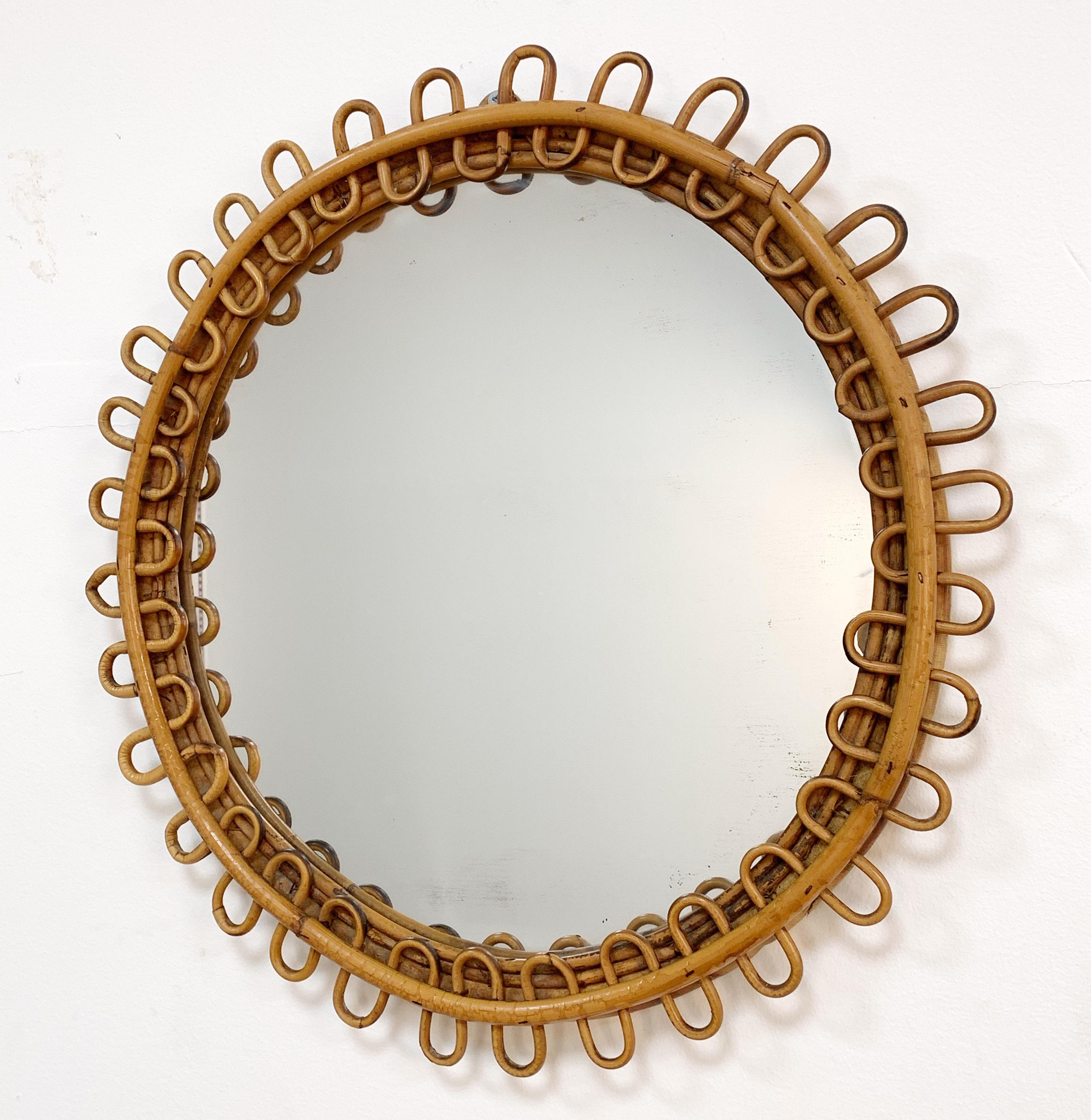 Wonderful round Italian riviera mirror with curved rattan beams and bamboo frame. 

This mirror is attributed to Franco Albini ad was produced in Italy, during 1950s. 

It has a diameter of 48 cm and with its light surface, it will add deepness